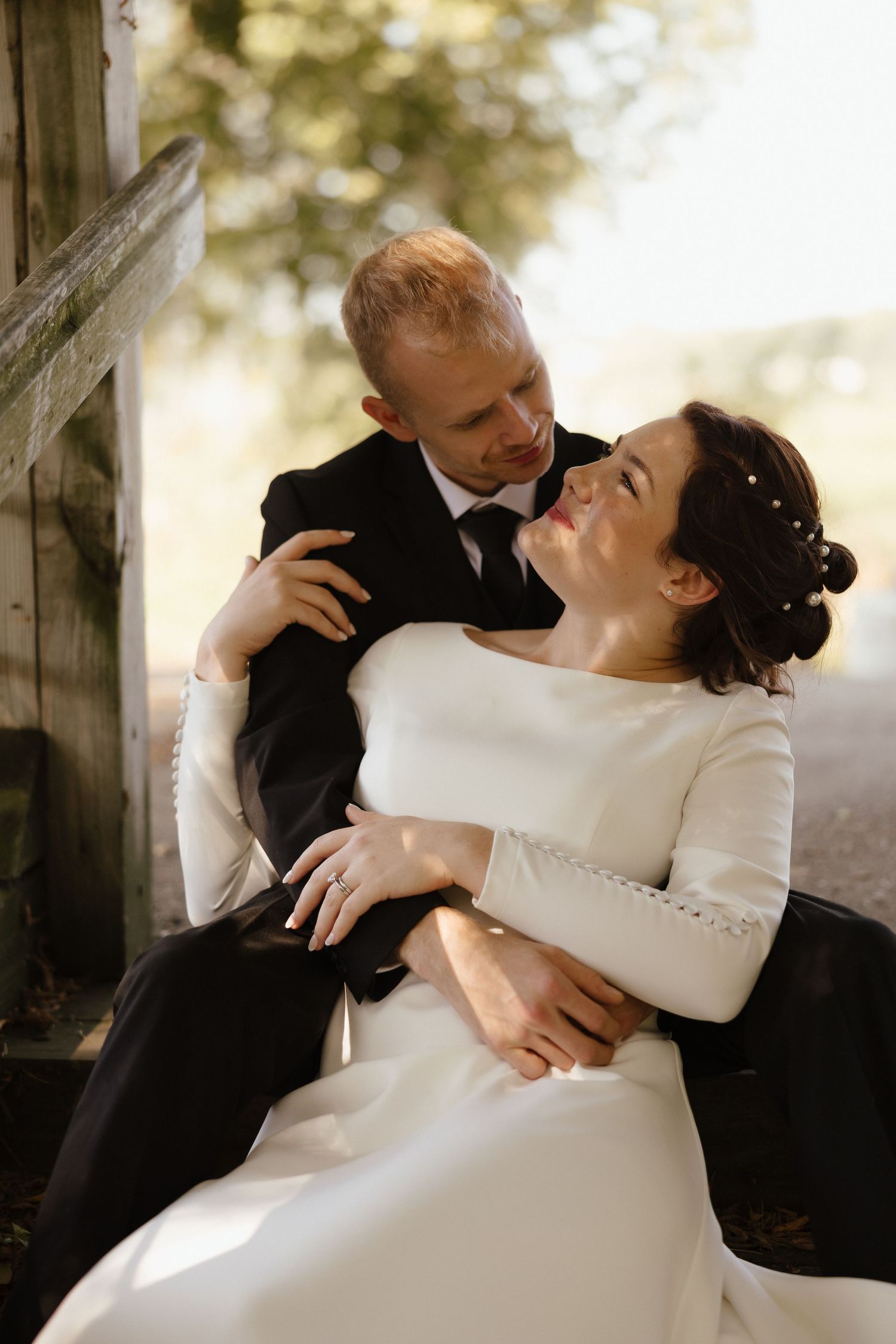 Romantic wedding couple sharing tender moments in soft natural lighting.