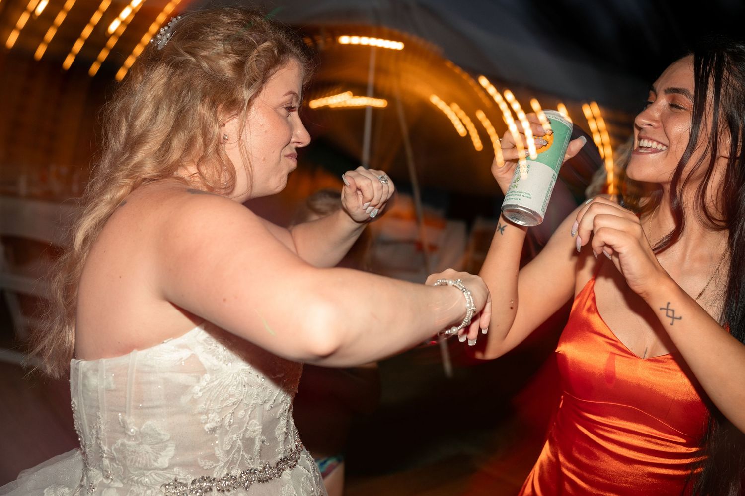 Wedding reception dance floor candid moments captured with warm lighting.
