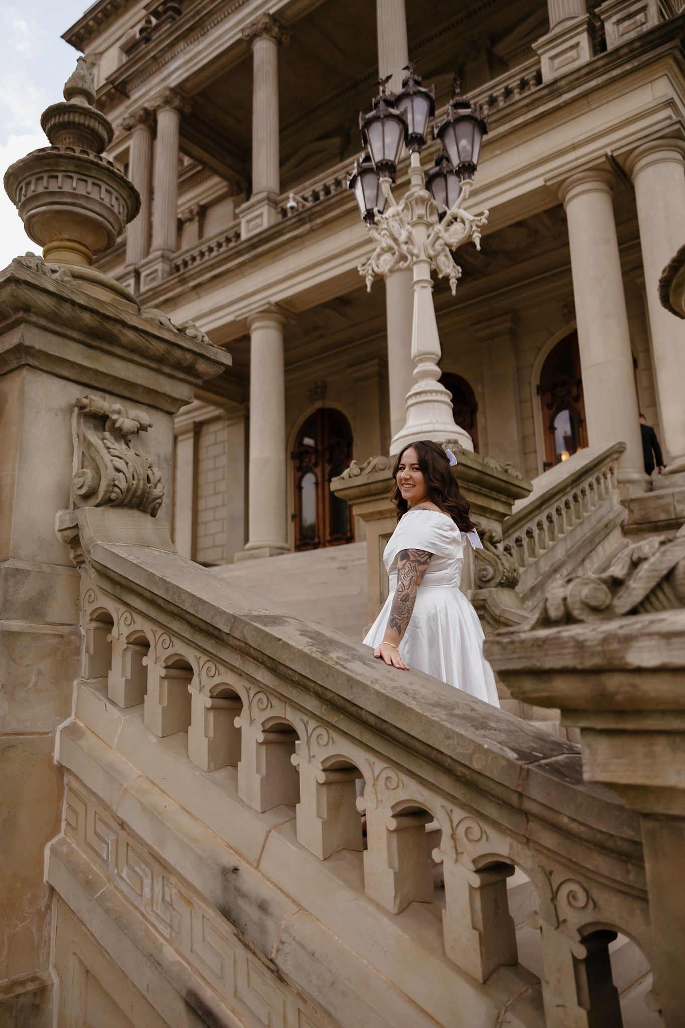 Romantic wedding photoshoot on the sweeping staircase of a classical architecture building.