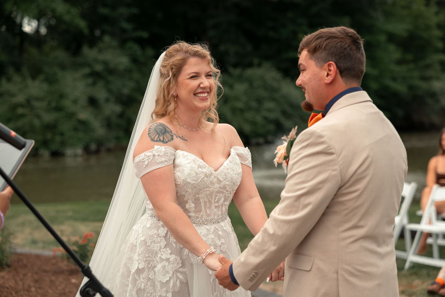 A joyful wedding celebration moment captured outdoors with elegant attire and natural scenery.