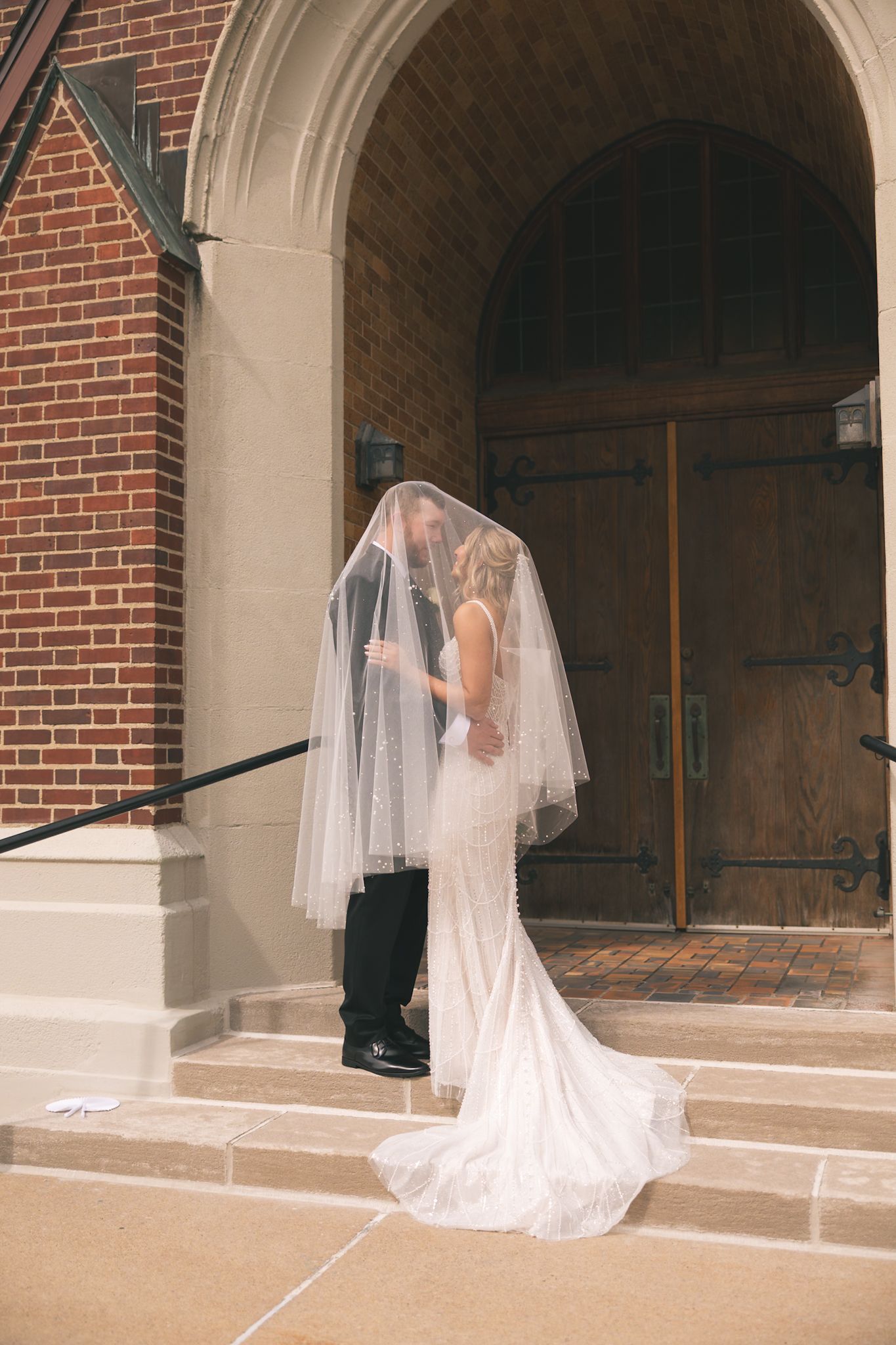 A sequence of wedding photos showing a bride in a flowing white gown and veil standing in front of a brick church entrance.