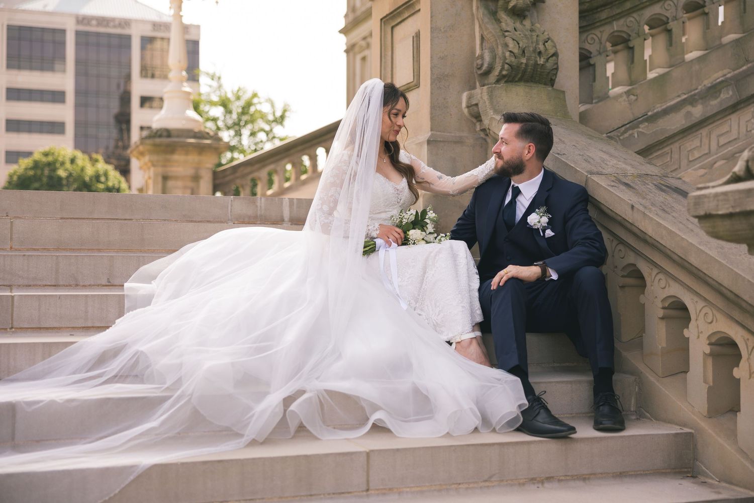Wedding couple poses on architectural steps in romantic photo sequence.