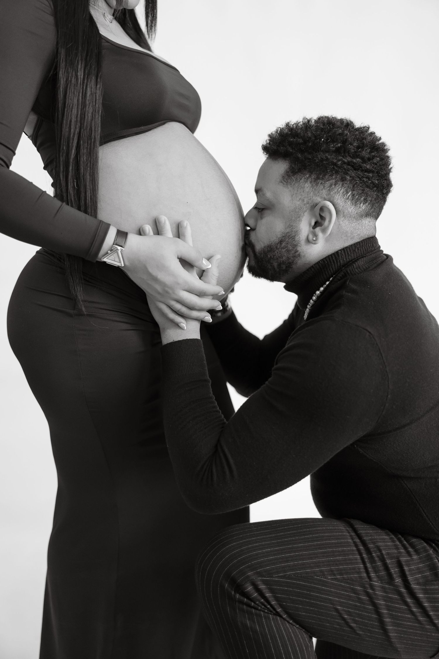 Black and white maternity photoshoot showing tender moments between expectant parents.