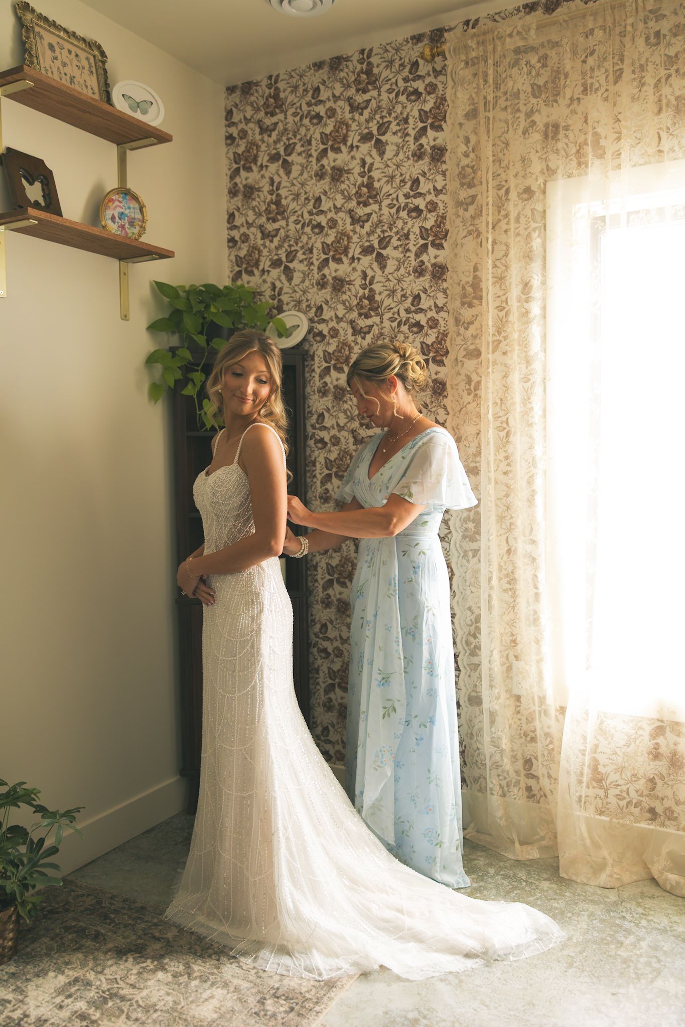 A sequence of photos showing two wedding dresses displayed in a room with floral wallpaper and lace curtains.