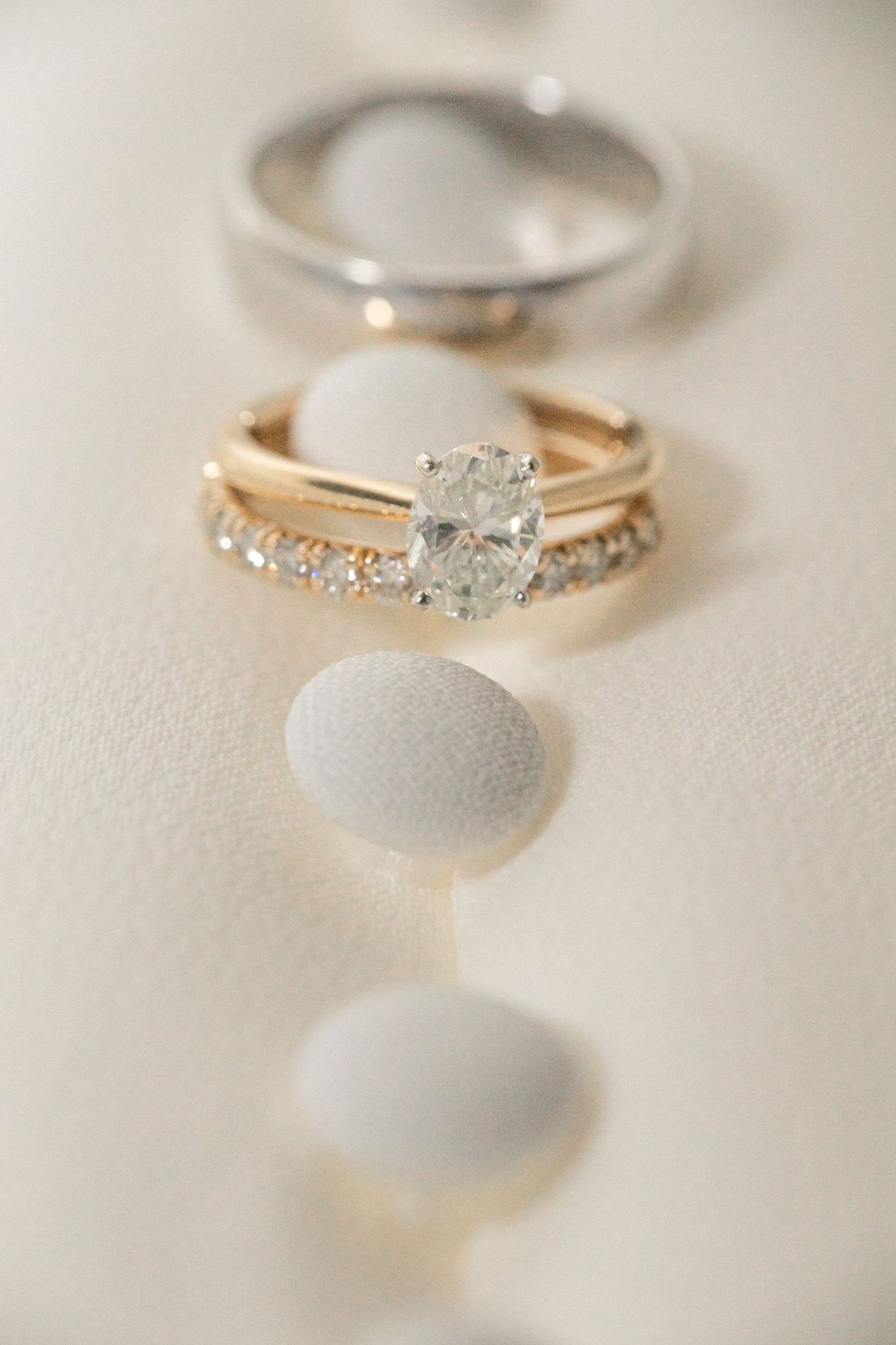 Detailed shot of rose gold engagement ring with diamond accents on light background.