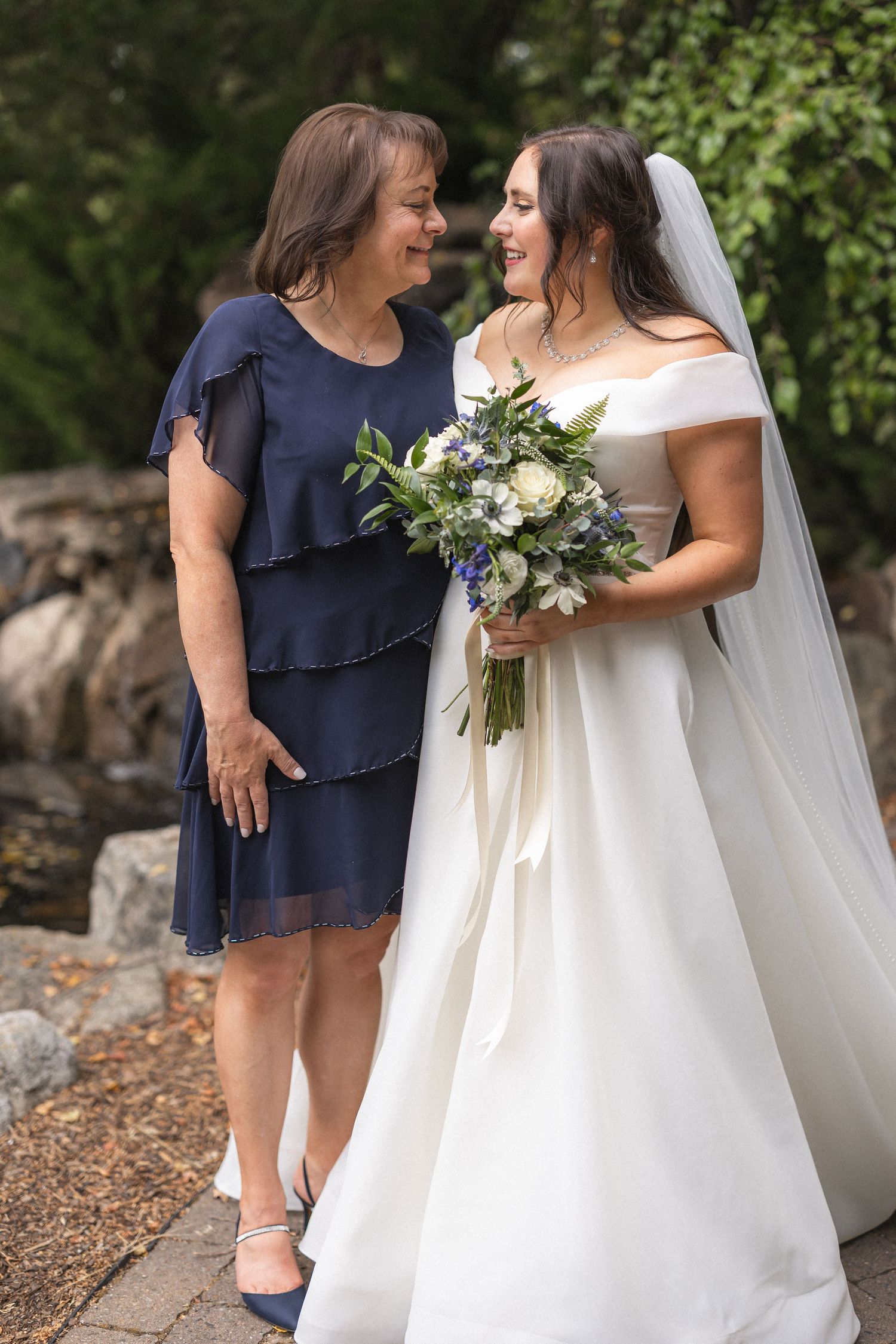 Joyful moment shared while holding elegant white and green wedding bouquet.