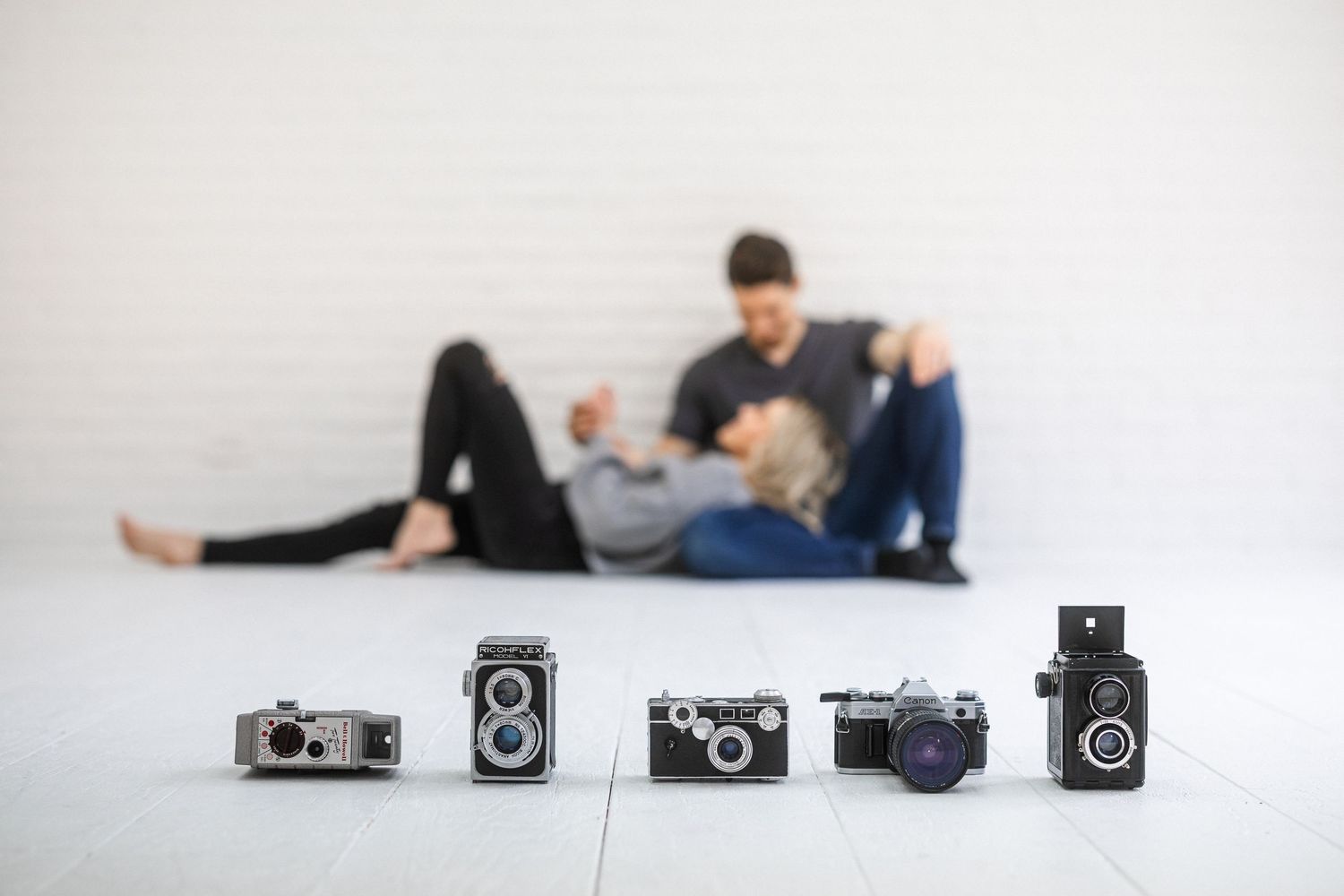 Creative flat lay photography composition with vintage cameras and artistic poses.