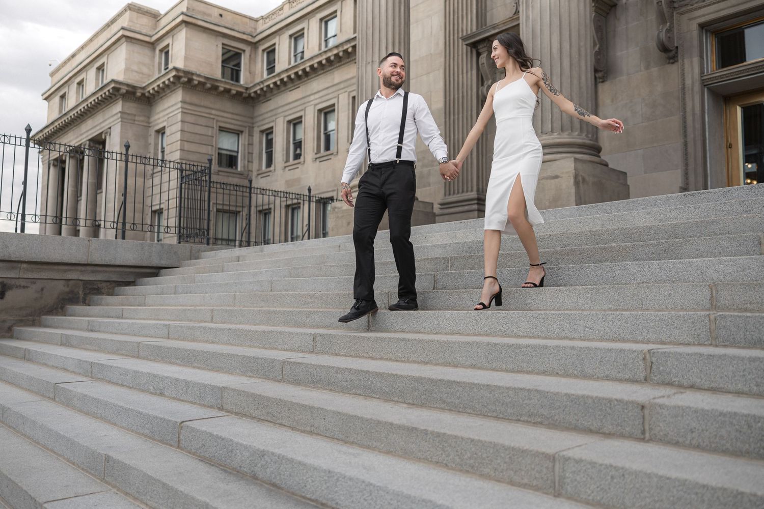 Two people dance together on wide stone steps of a historic building.