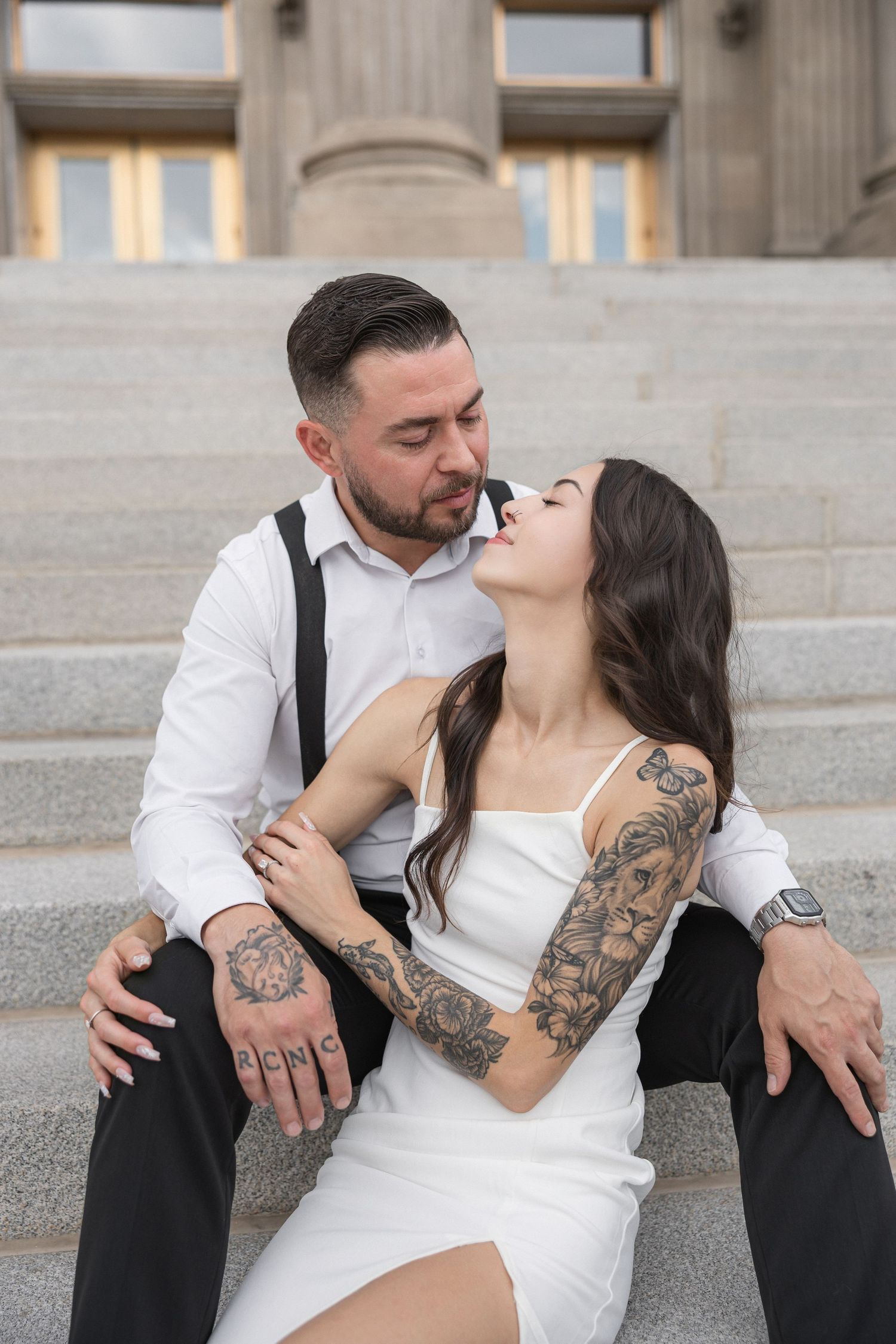 Romantic couple embraces on stone steps during photo session.