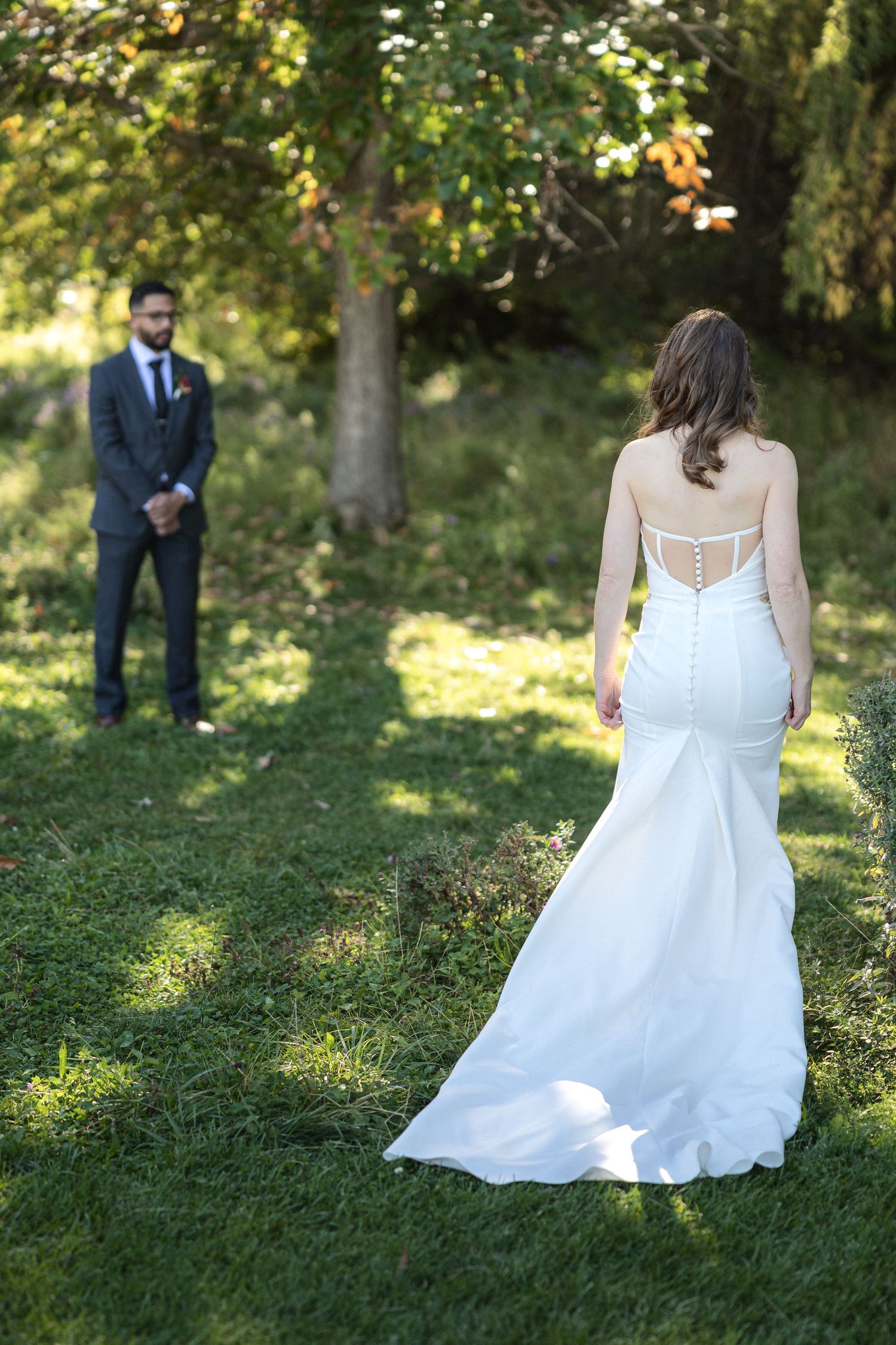 Wedding portraits in sunlit garden setting with natural greenery.