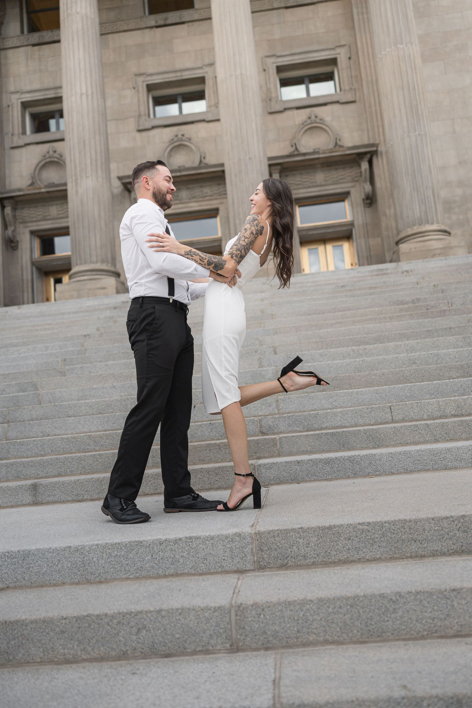 Playful dance sequence on the steps of a neoclassical building with stone columns.