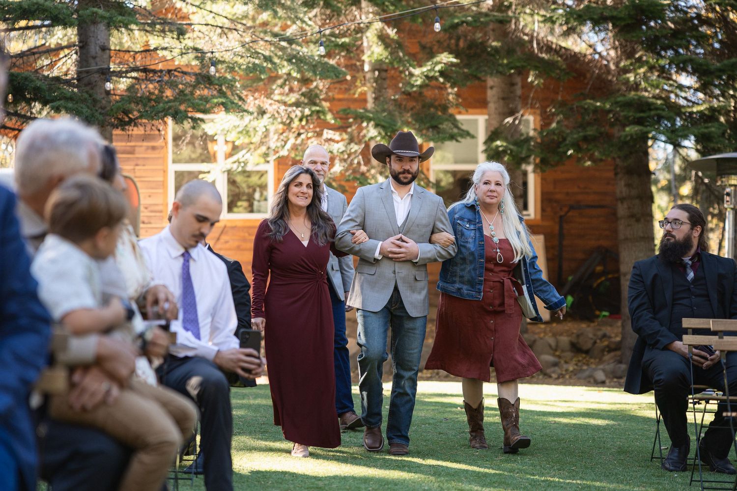 Wedding guests gather on a lawn for an outdoor celebration.