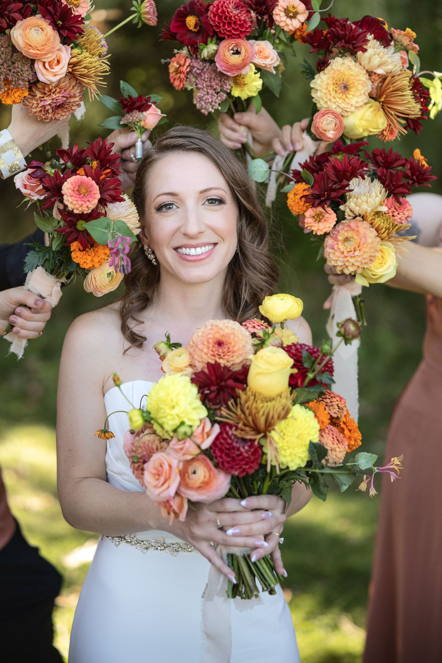 Close-up of stunning fall wedding bouquets with burgundy, peach and yellow blooms.