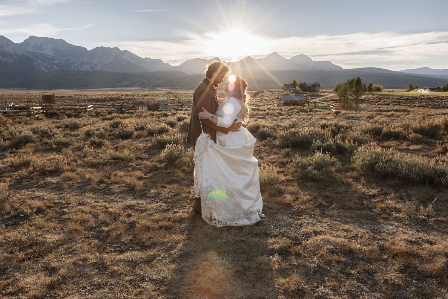 Scenic mountain vista with sun rays breaking through clouds over arid desert landscape.