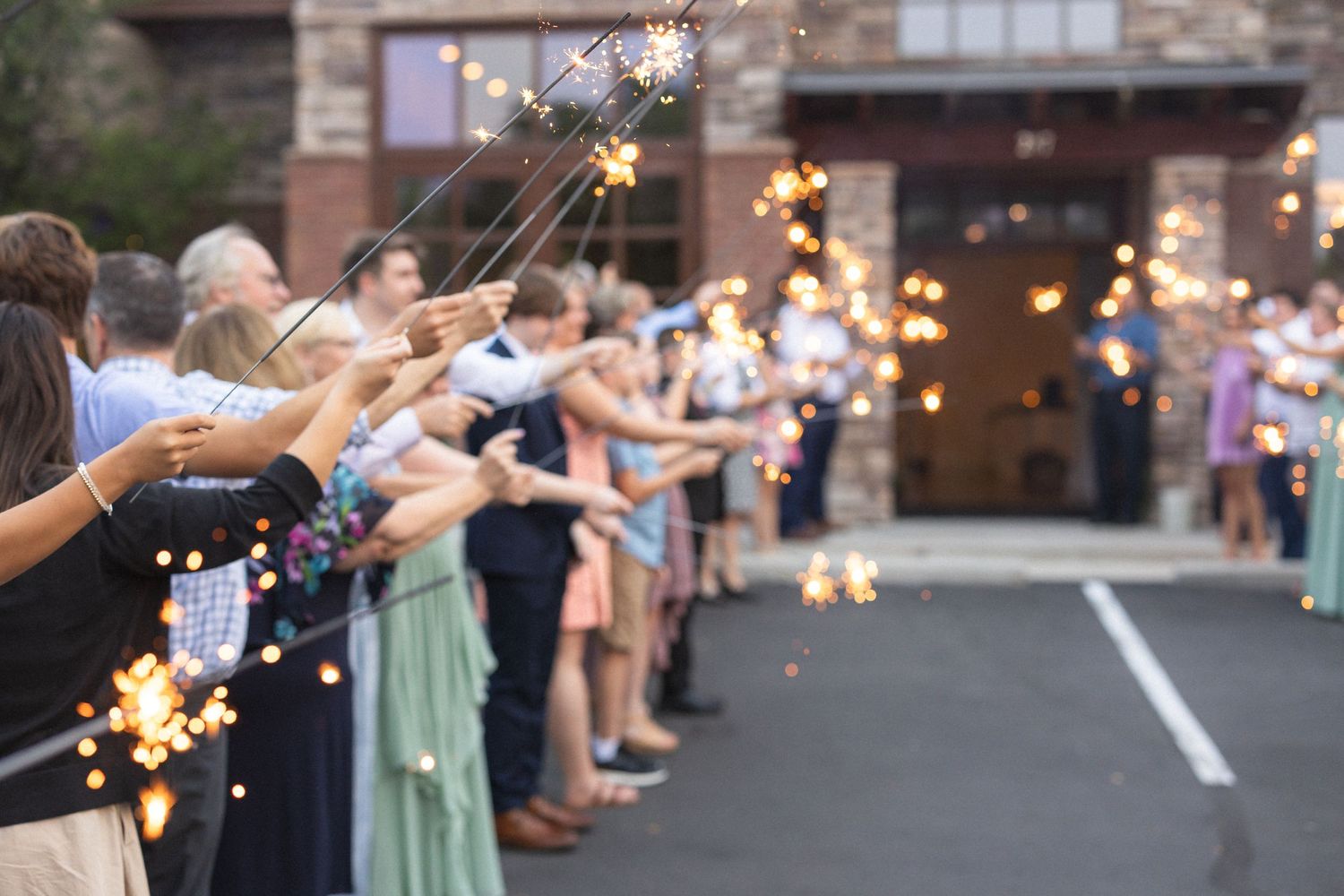 Sparklers light up the night as wedding guests form an exit tunnel during the sendoff.