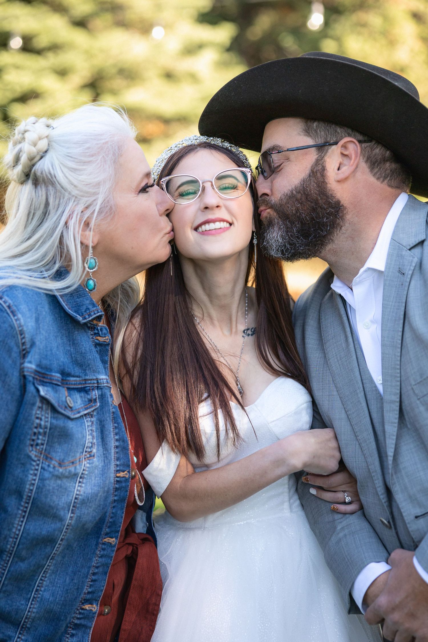 Candid moment of affection and laughter at outdoor wedding celebration.