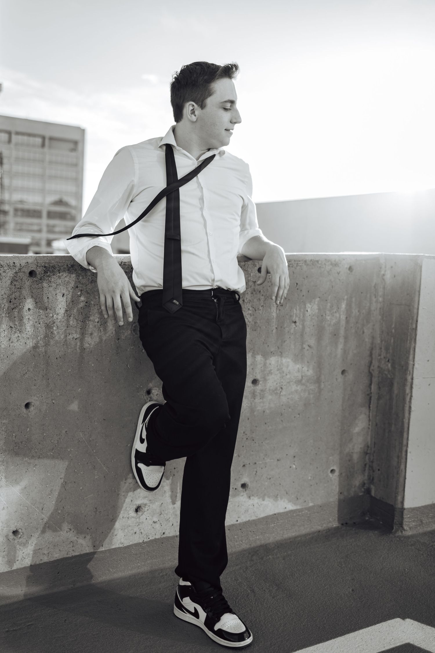 Black and white urban fashion photography featuring classic formal wear against concrete architecture.