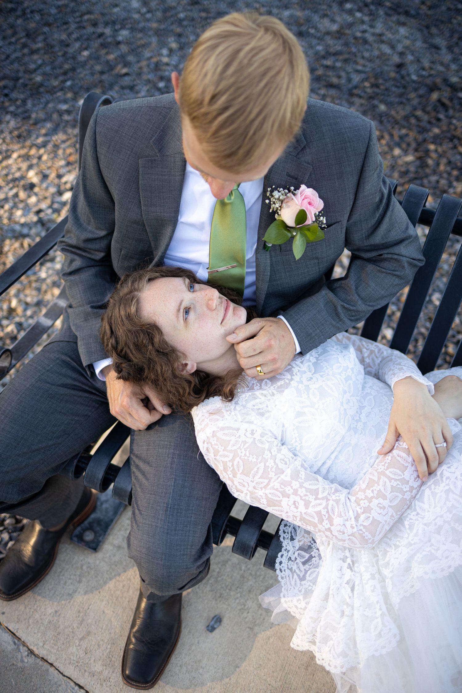 Romantic overhead shot of couple sharing tender moment on park bench.