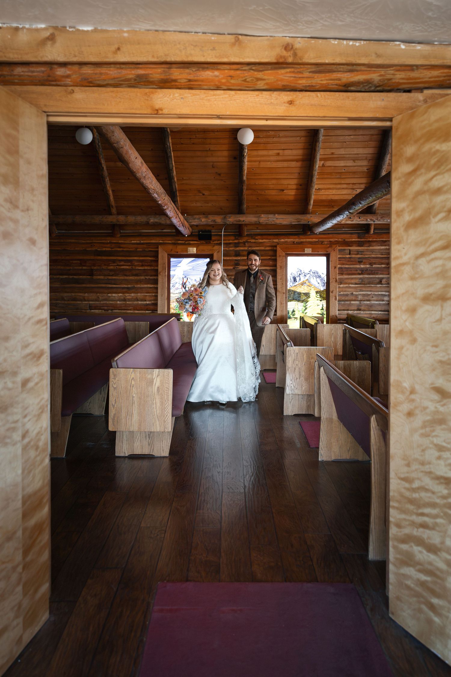 Interior of a rustic wooden barn venue with natural light streaming through windows.