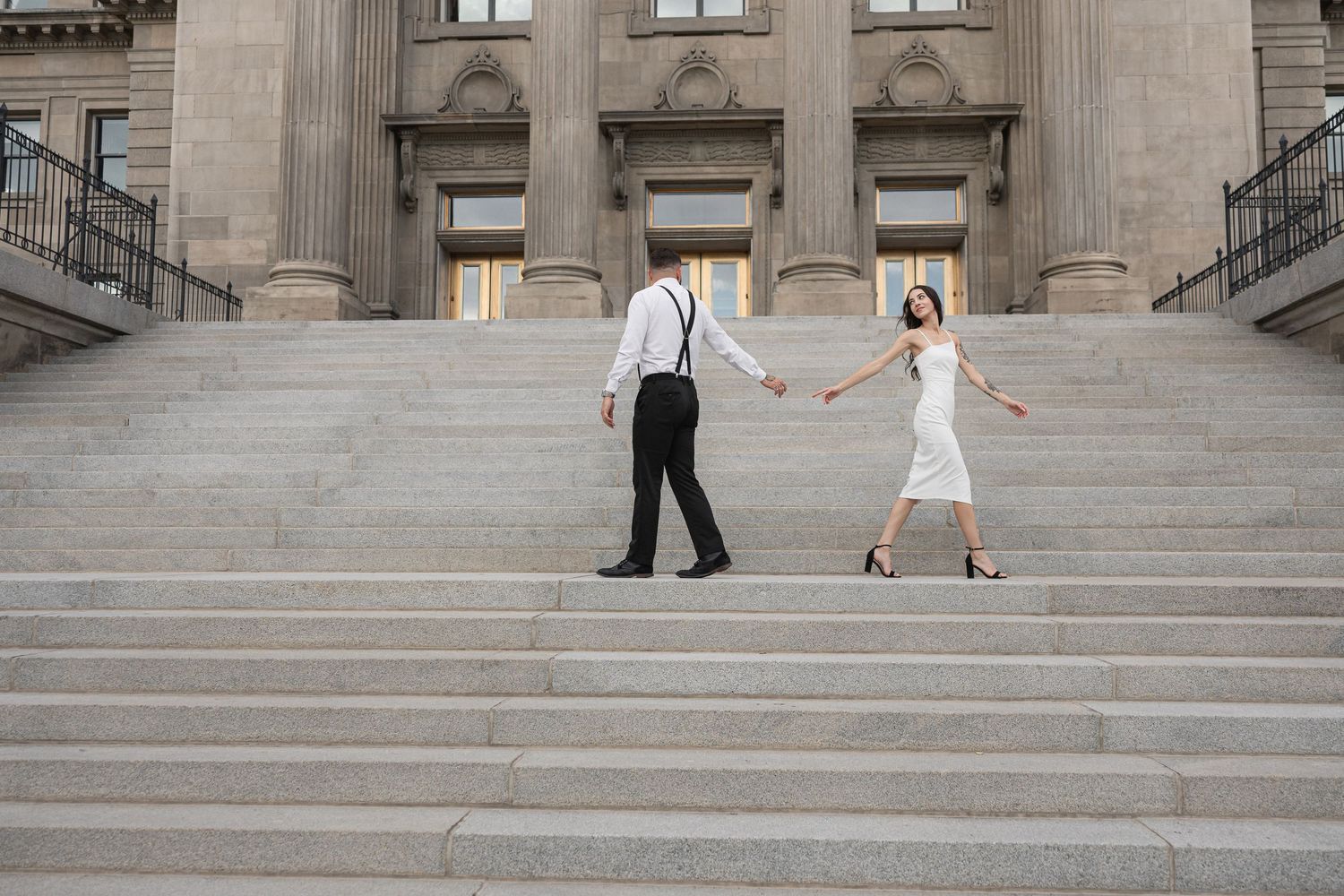 Distant view of couple descending grand architectural steps.