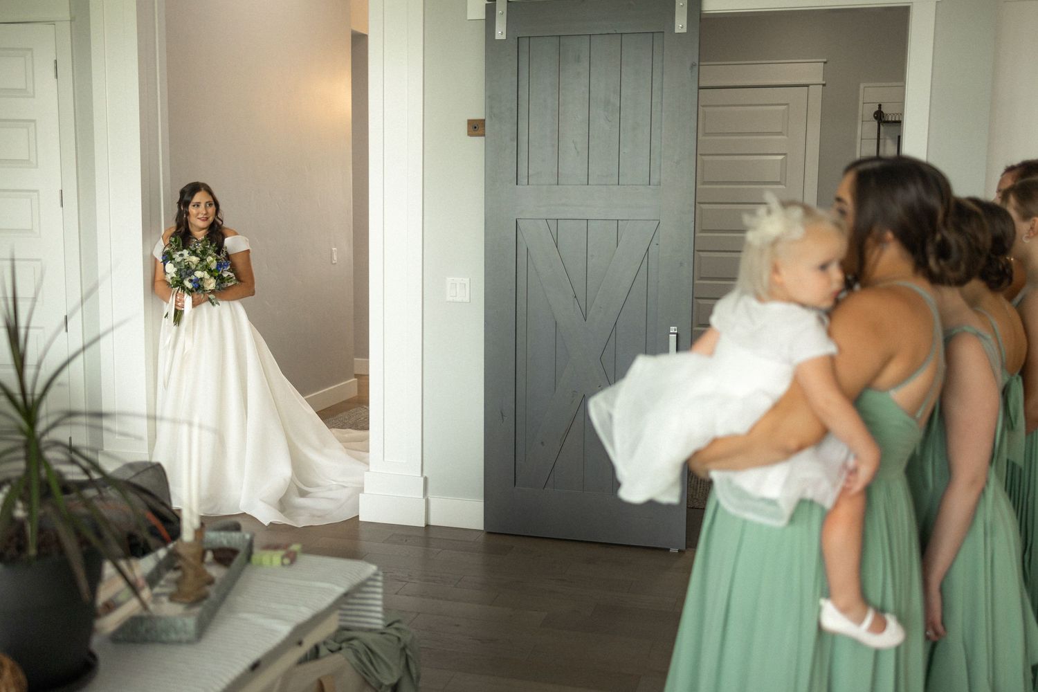 Wedding preparation scene with bridesmaids in sage green dresses.