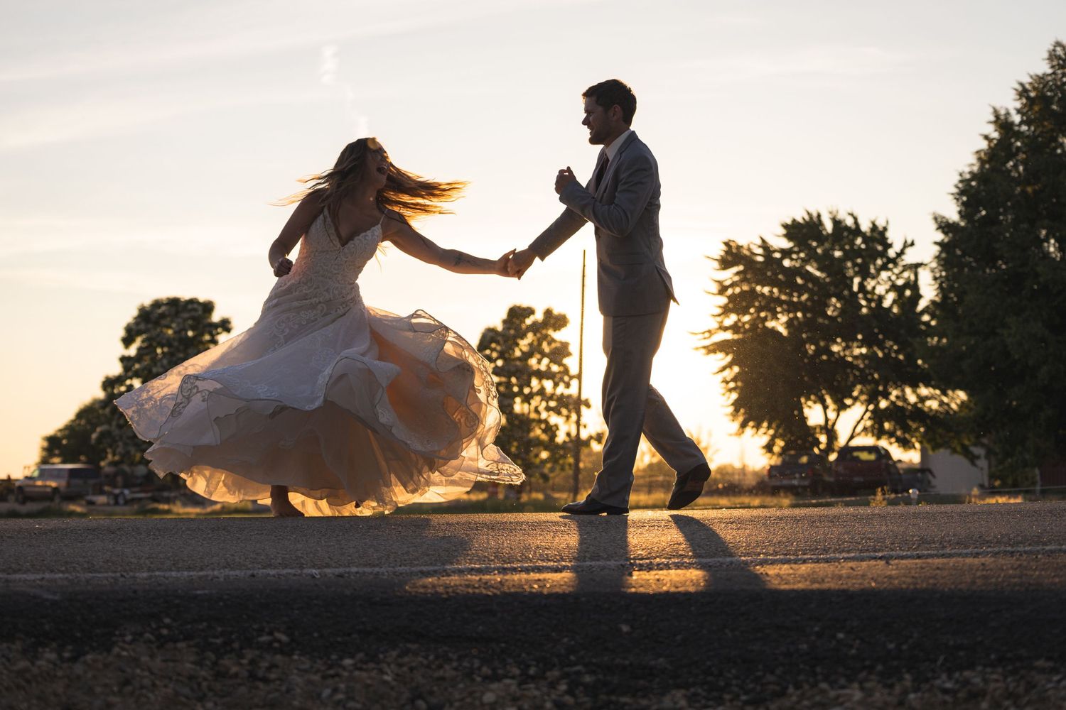 A couple dances together at sunset creating a romantic silhouette against the sky.
