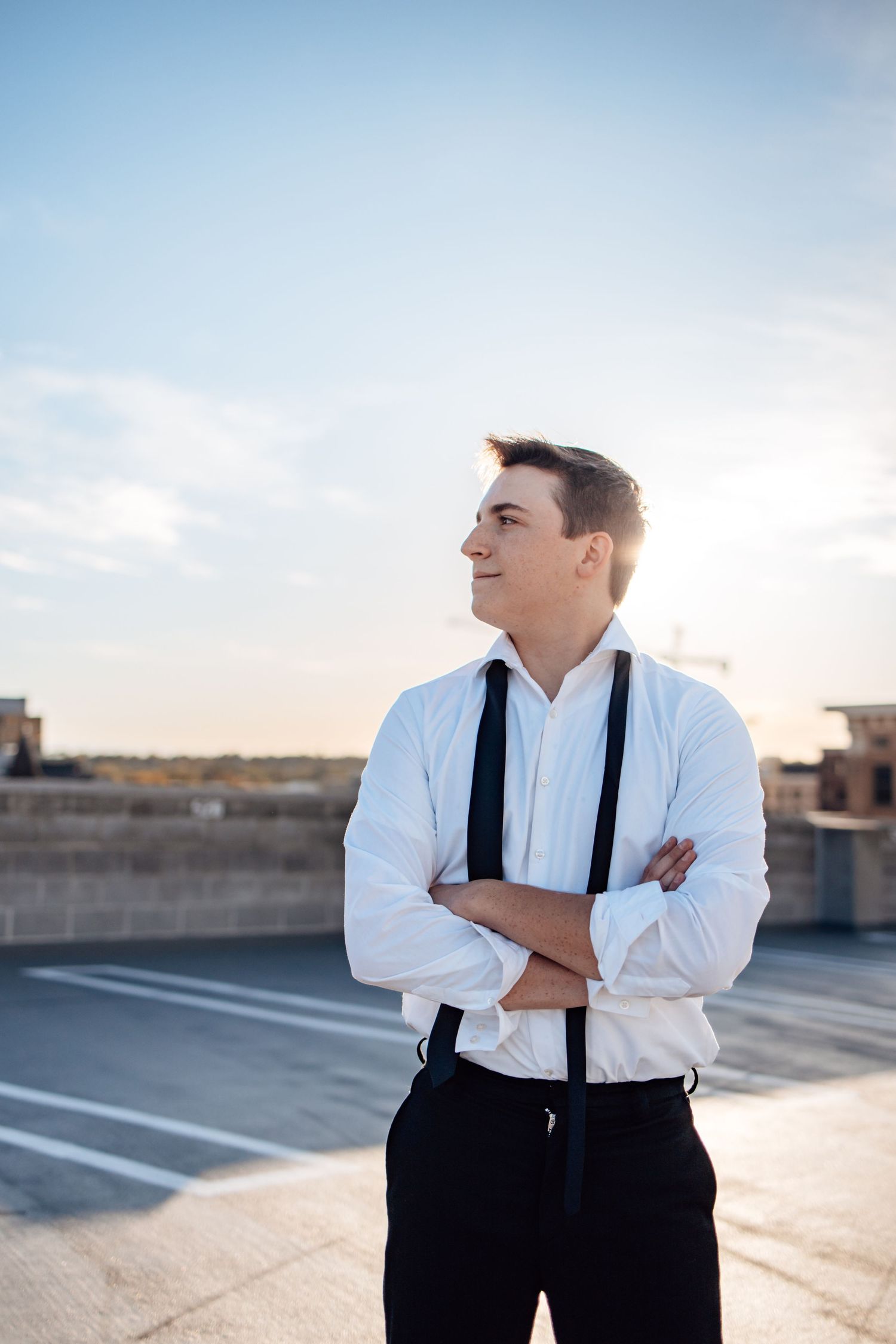 Professional fashion photography in a parking garage with dramatic sunset lighting and formal attire.