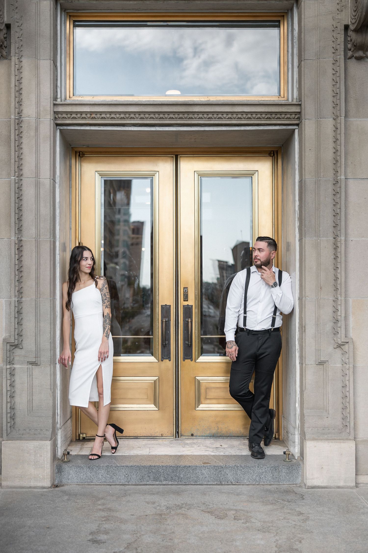 Exterior view of a building with gold-framed glass doors and classical stone architecture.