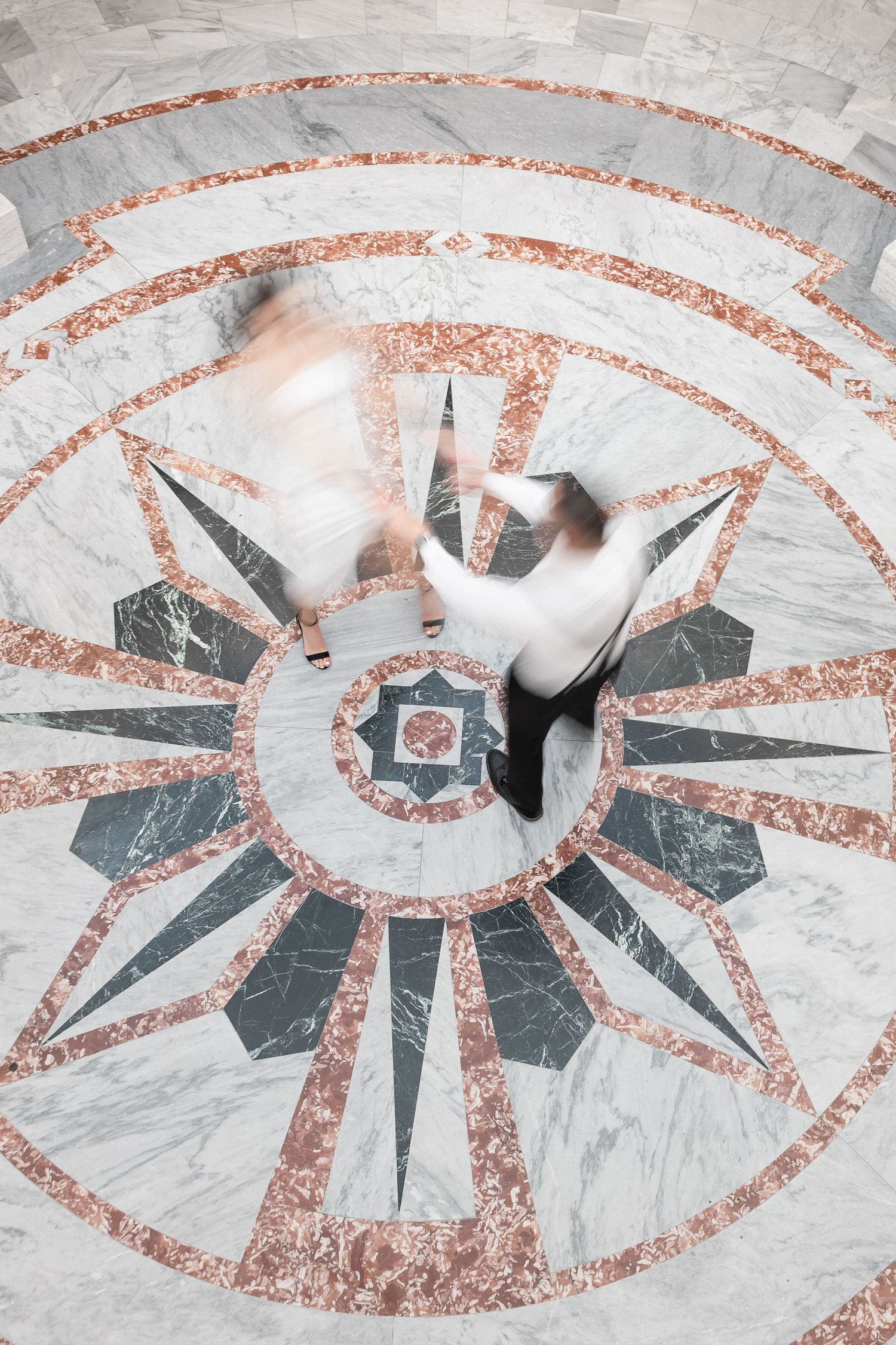 Decorative ceiling detail showing a geometric eye pattern in marble and copper tones.
