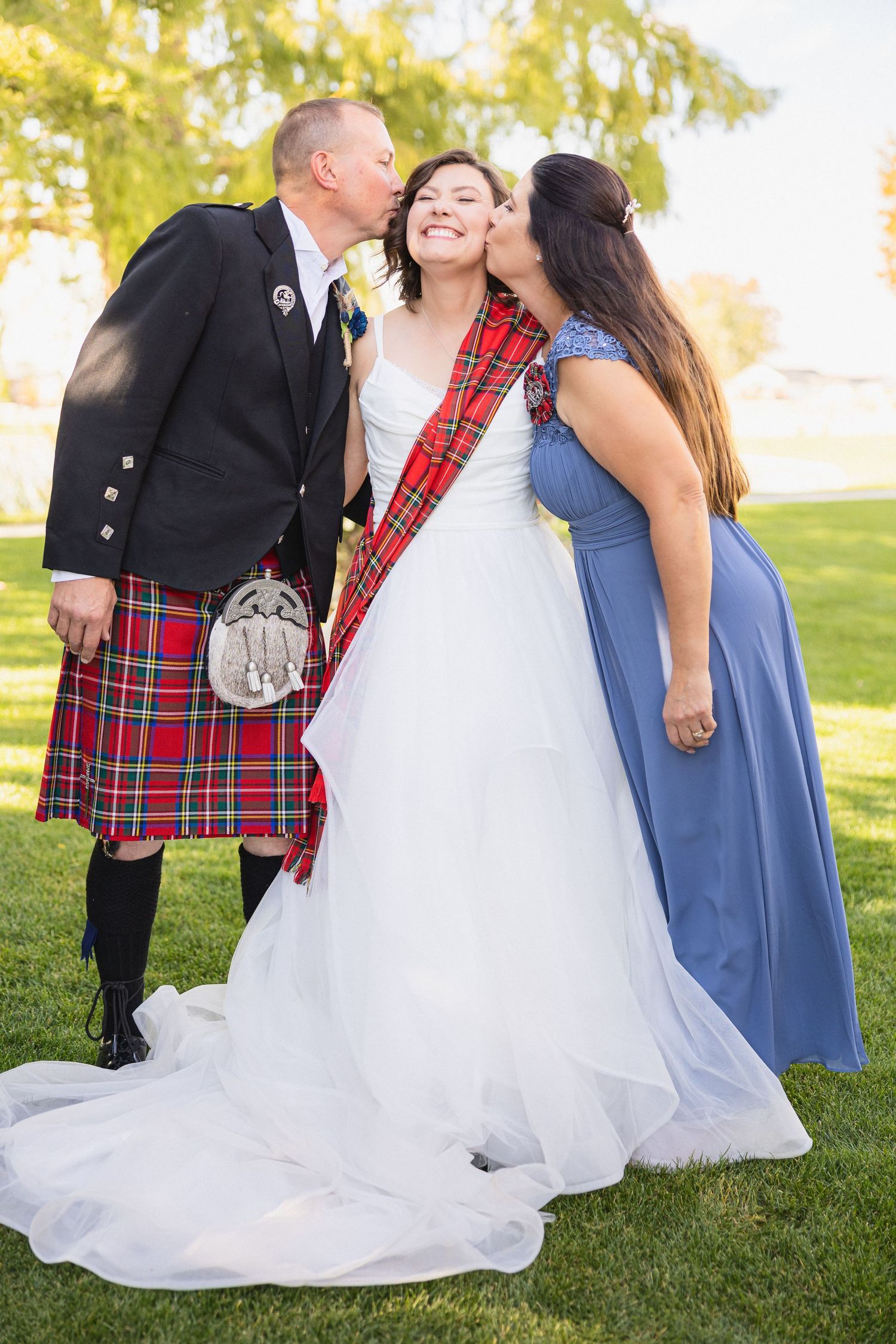 Wedding celebration moment captured outdoors with Scottish and formal attire.