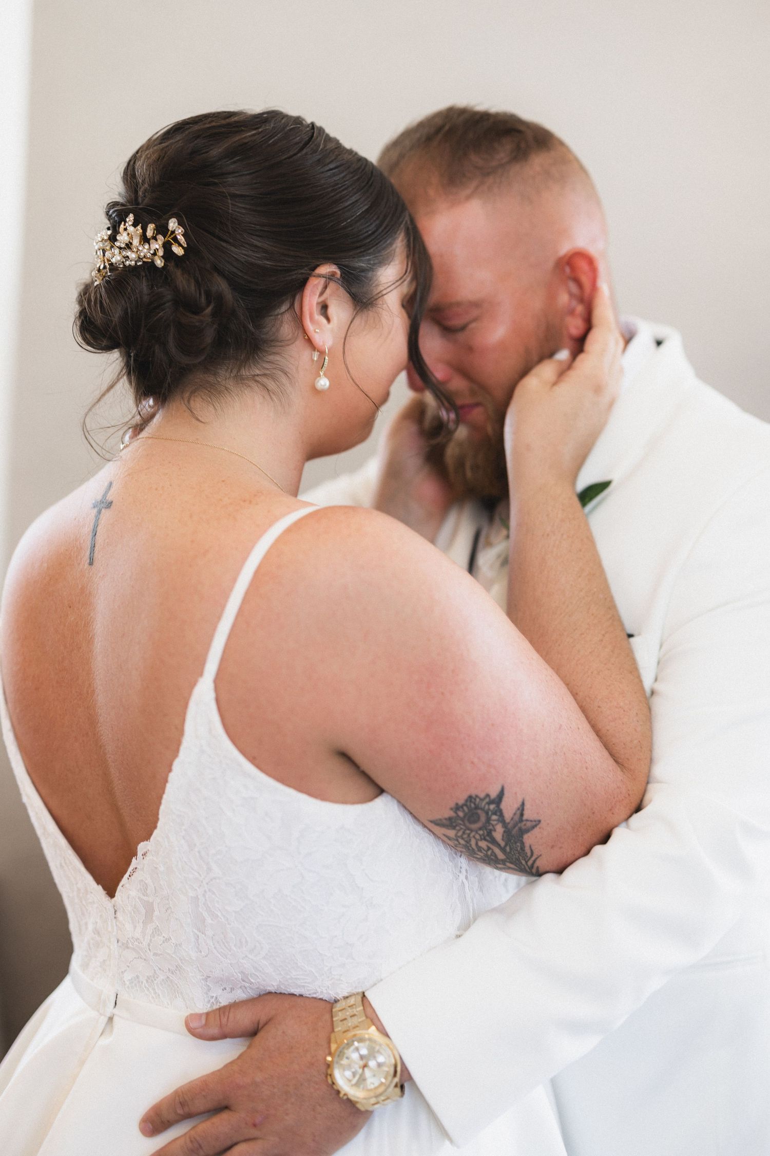 Intimate wedding moment showing couple in white attire sharing a close embrace.