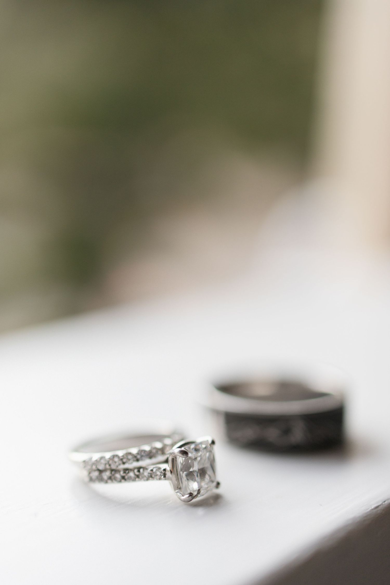 Diamond engagement ring with delicate band captured in soft focus macro shot.
