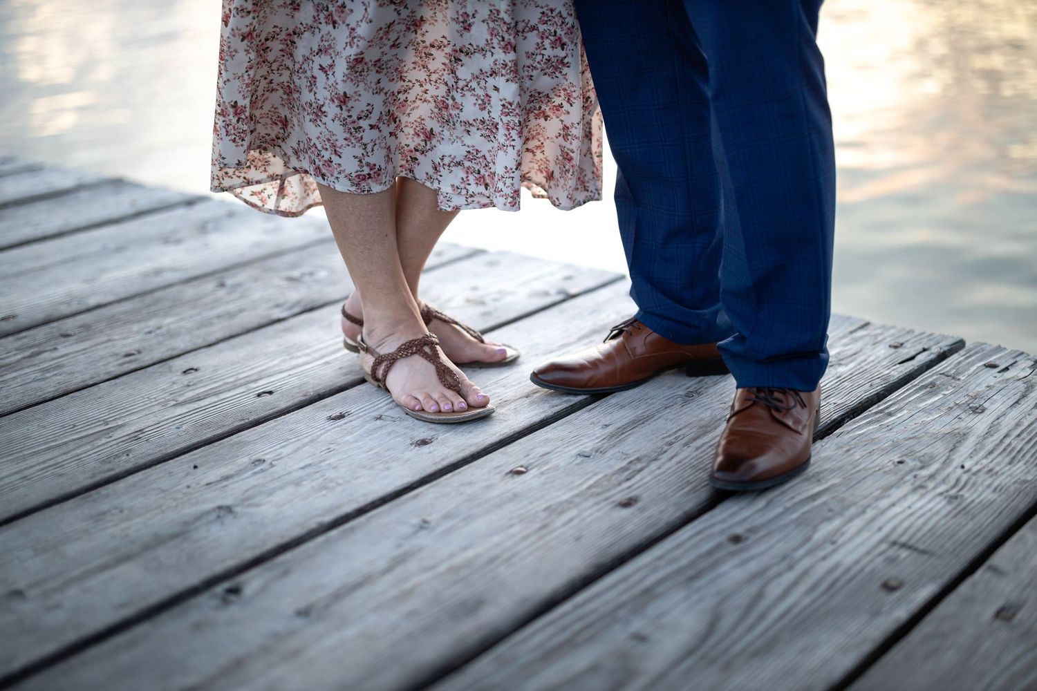 Close-up of feet dancing on weathered wooden dock.