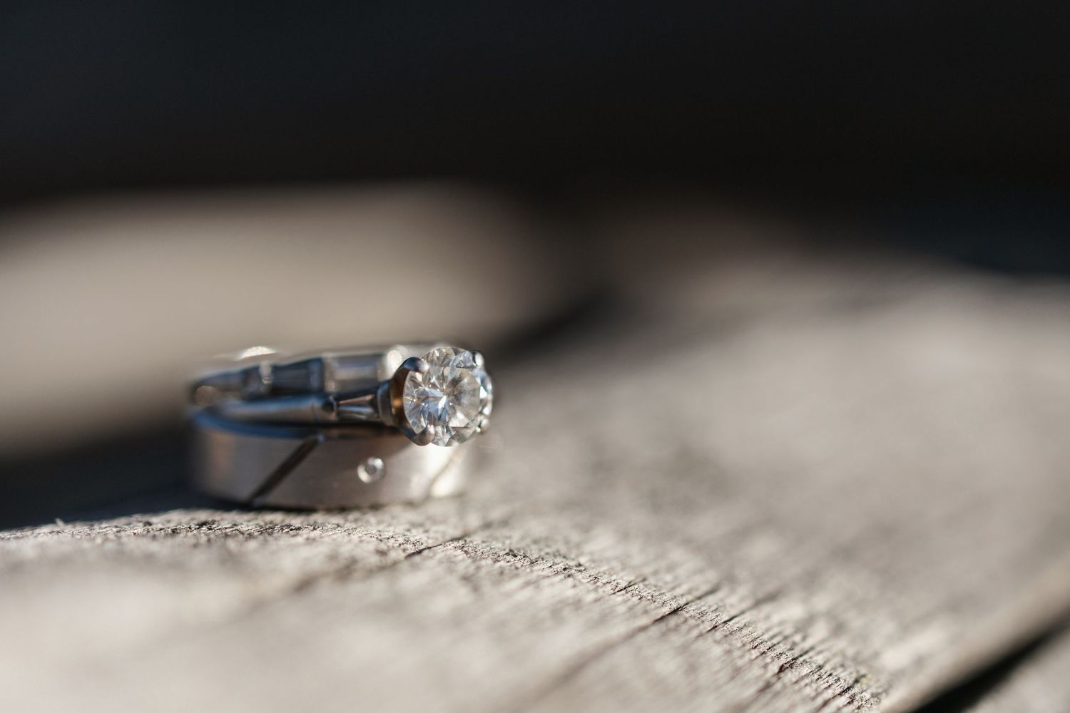 Close-up of wedding rings with delicate details on a textured surface.