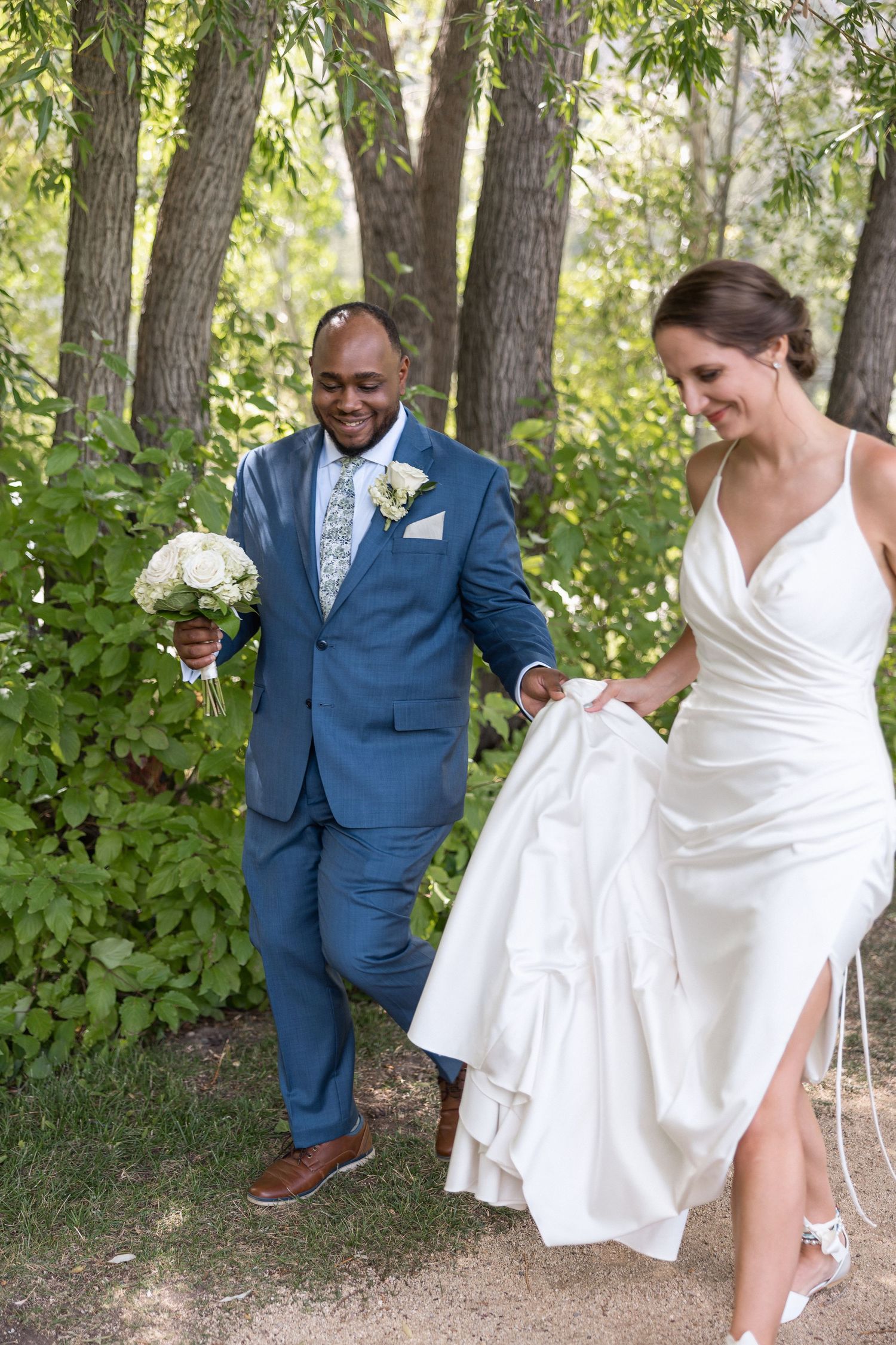 Candid wedding moments captured under shady trees in a natural outdoor setting.