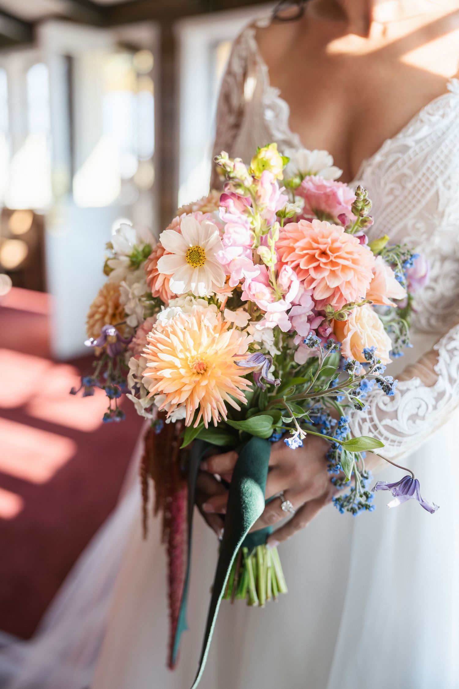 Beautiful pastel floral bouquets with peach dahlias and mixed flowers tied with teal ribbons.