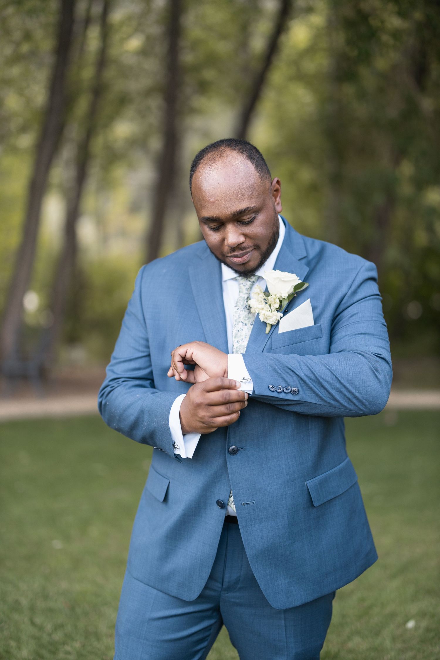 Wedding attire detail shots showing blue suit jacket and boutonniere adjustments.