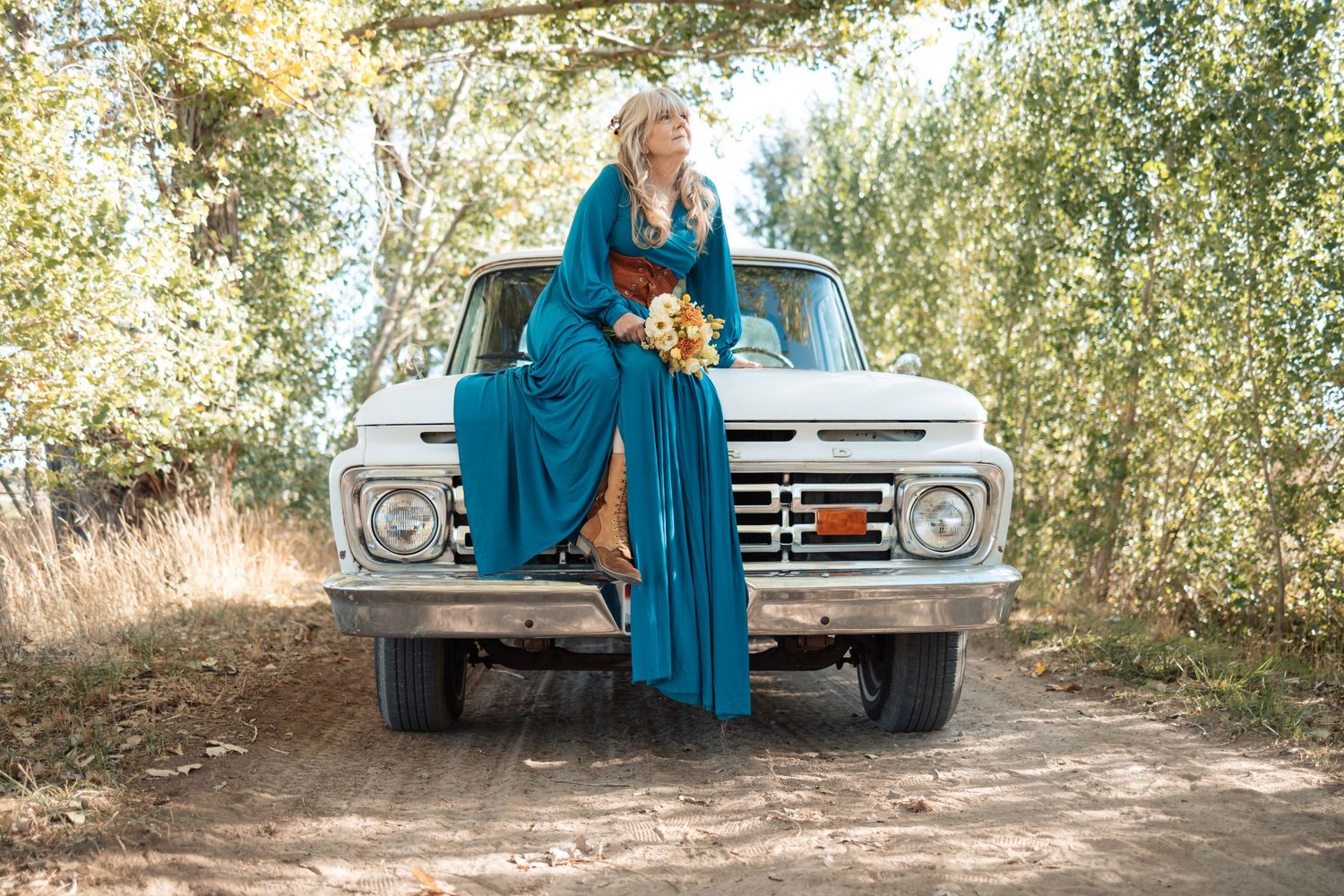 Vintage car serves as backdrop for romantic outdoor photoshoot in teal tones.