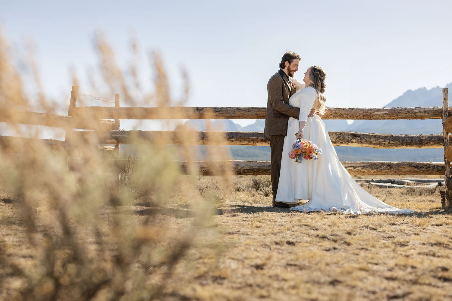 A panoramic view of a wedding ceremony in a desert landscape with distant mountains.