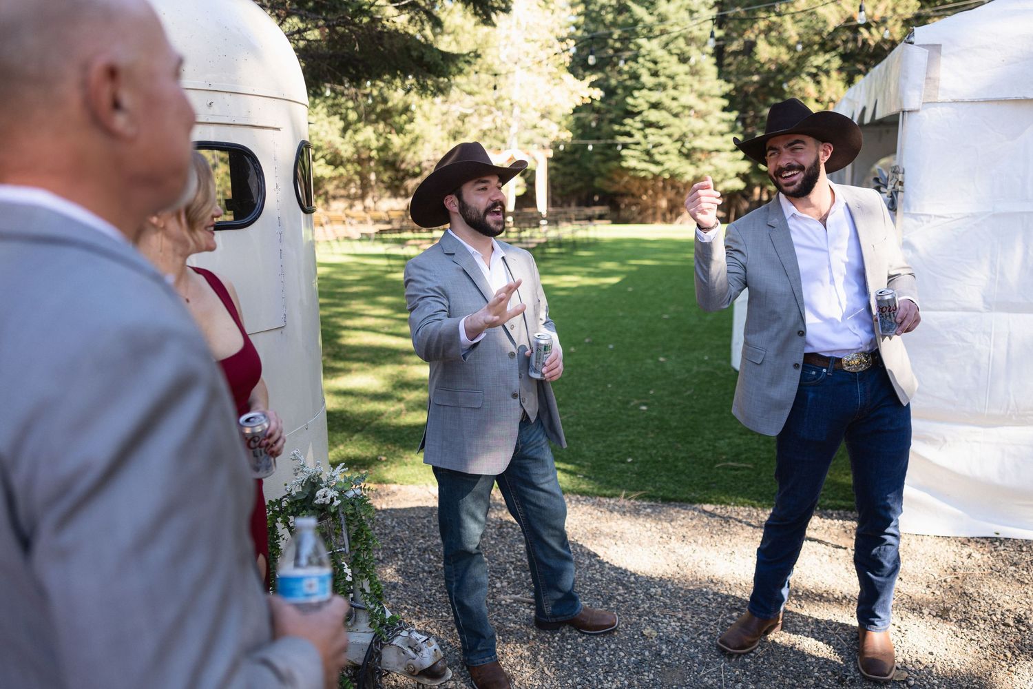Group of men in grey suits and cowboy hats chatting outdoors.