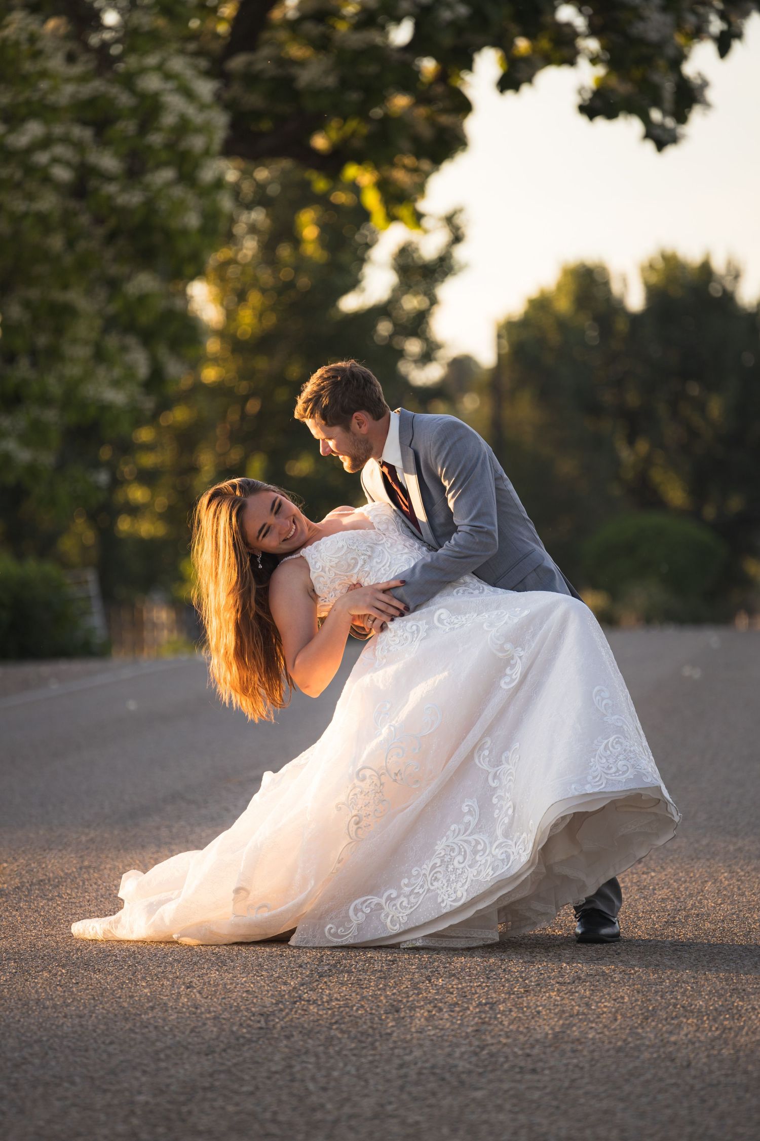 A romantic dance dip captured during a wedding photoshoot at golden hour.