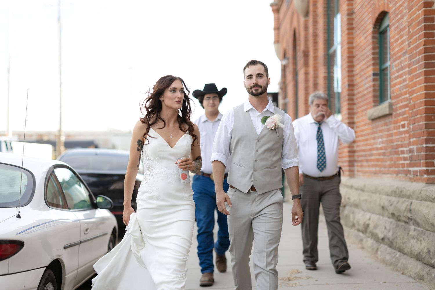 Newlyweds walking together outside historic brick building after ceremony.
