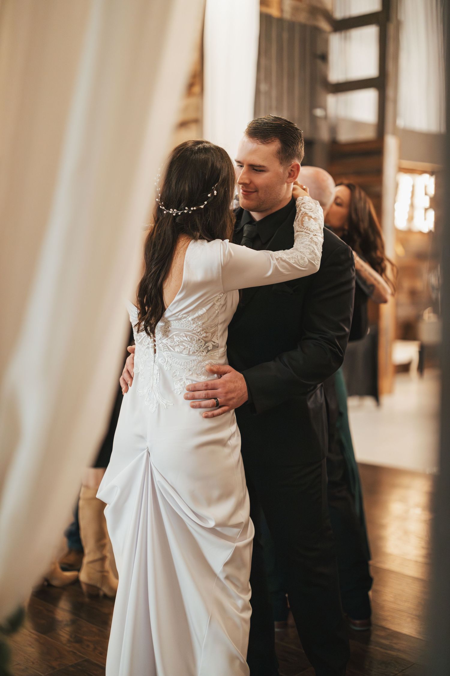 Romantic dance moment at an indoor wedding reception with soft lighting.