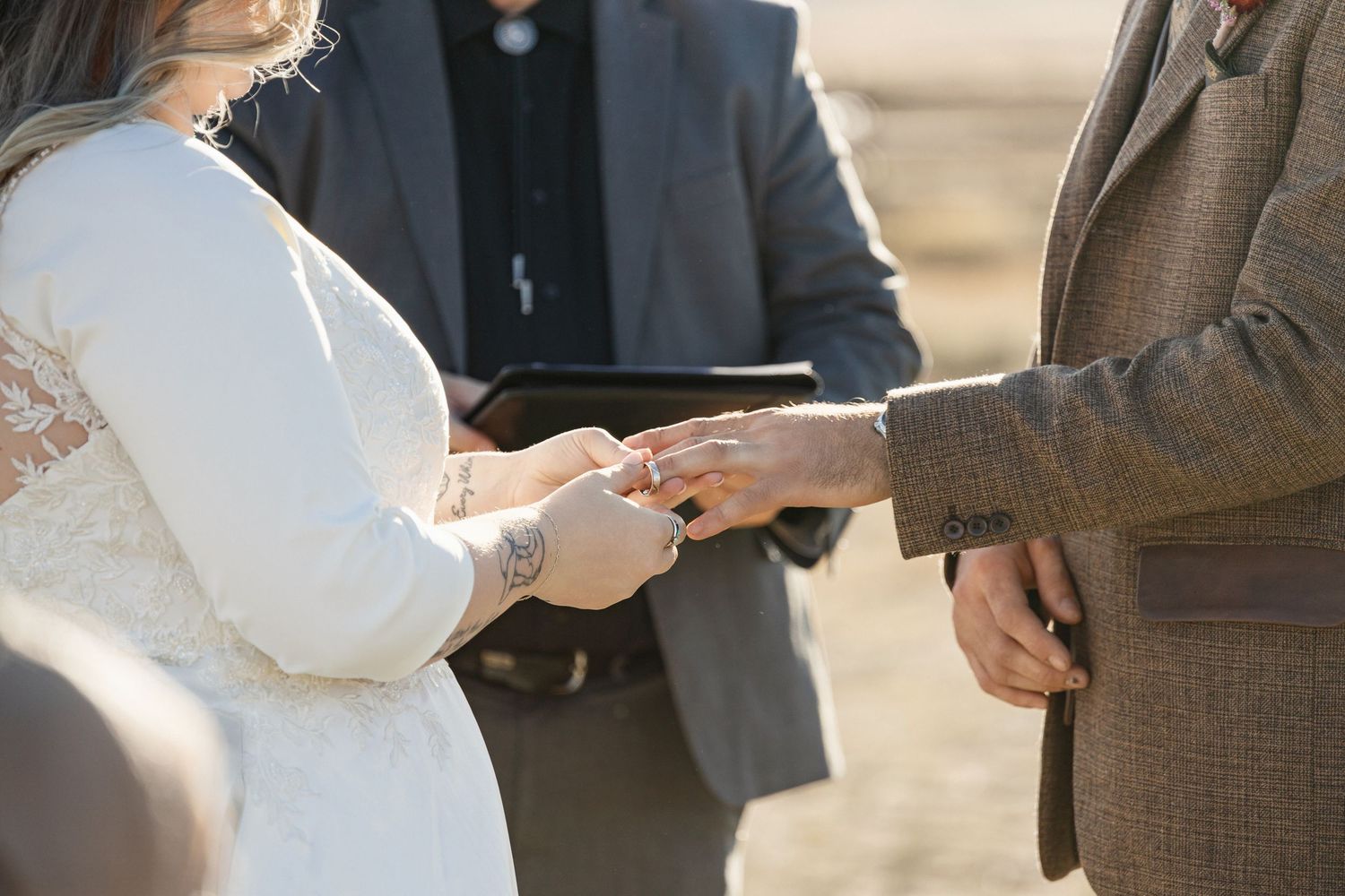 Wedding ceremony details showing formal attire and hands during the service.