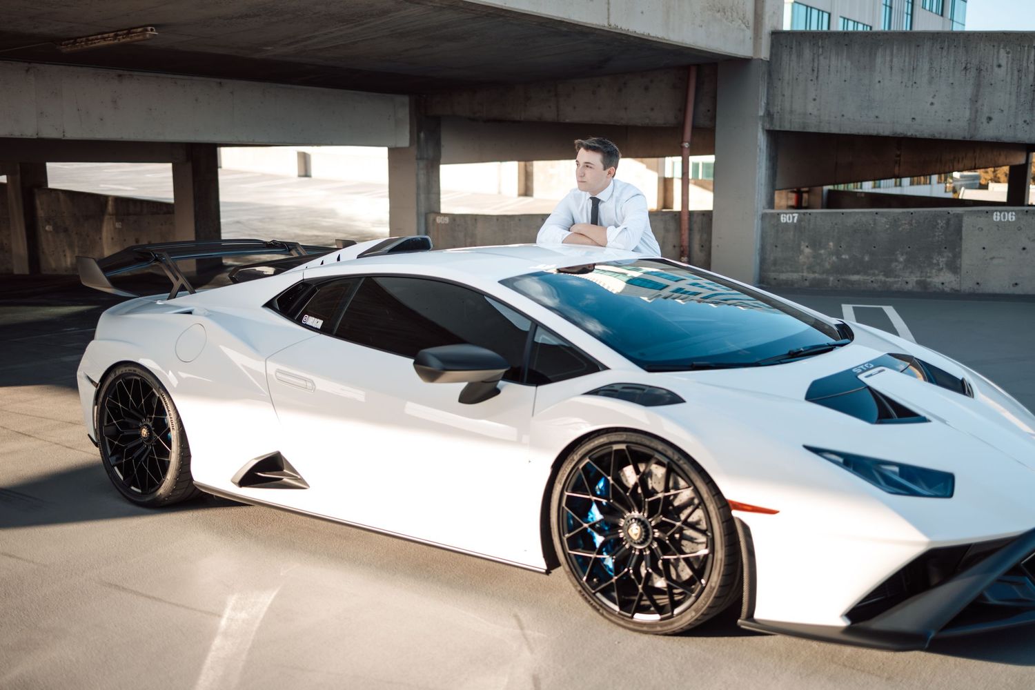White Lamborghini Aventador supercar showcases sleek design and black wheels against urban backdrop.