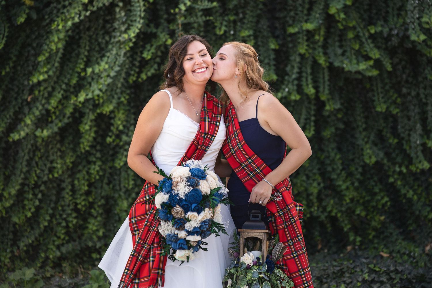 Joyful wedding moment captured against lush green foliage backdrop.