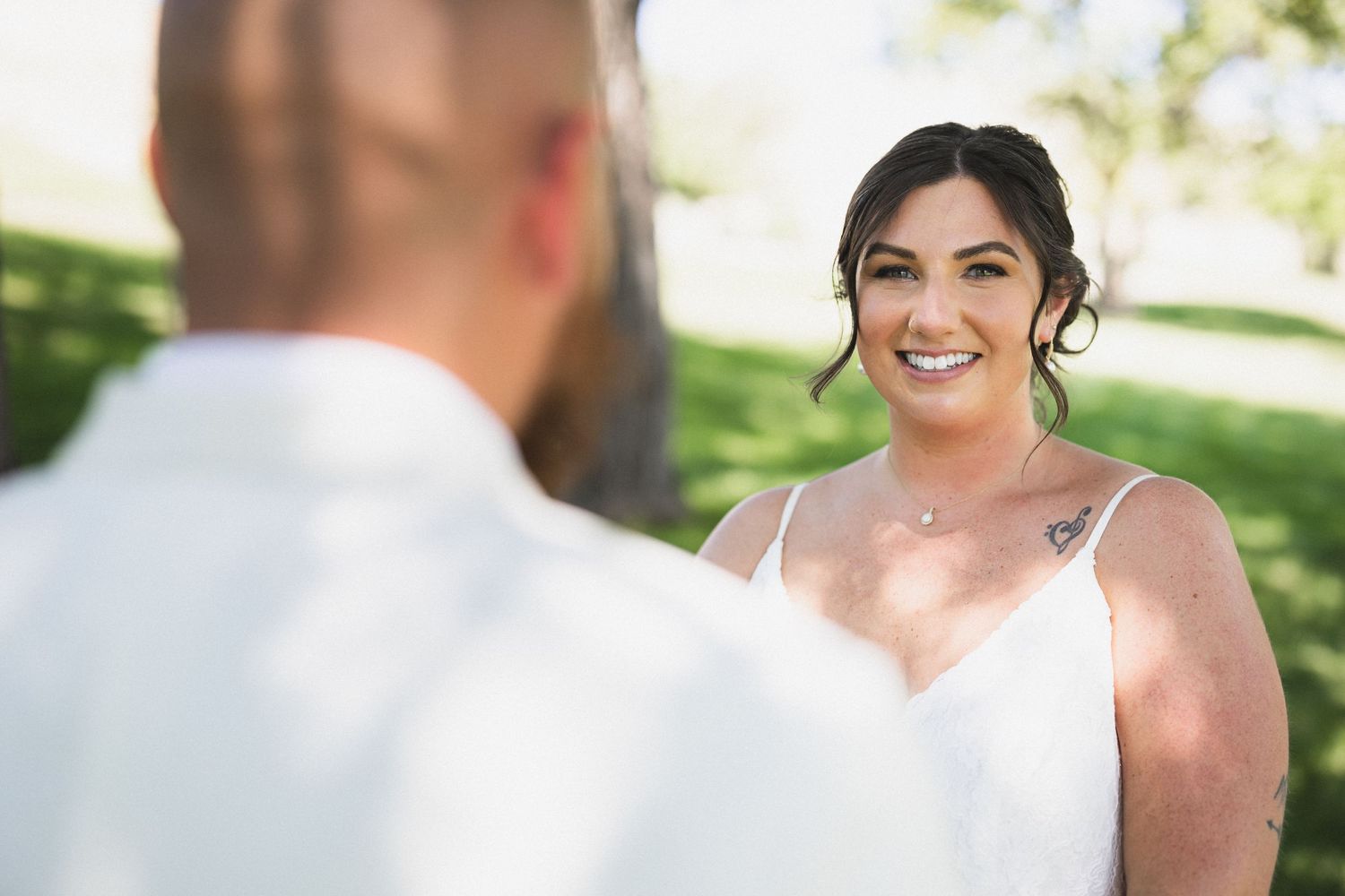 Romantic outdoor wedding portrait captured in natural sunlight.