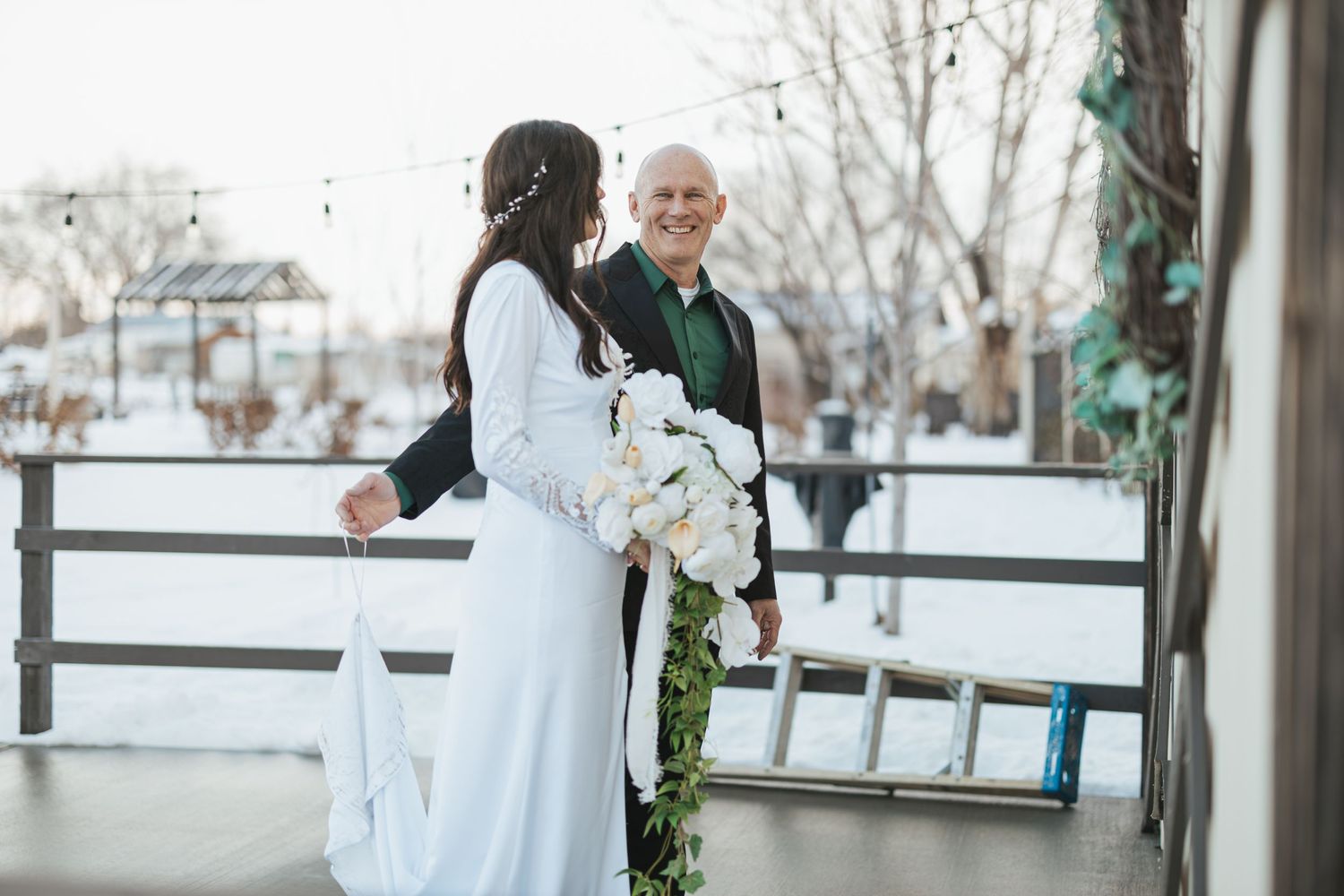 Winter wedding scene on outdoor porch with rustic decor.