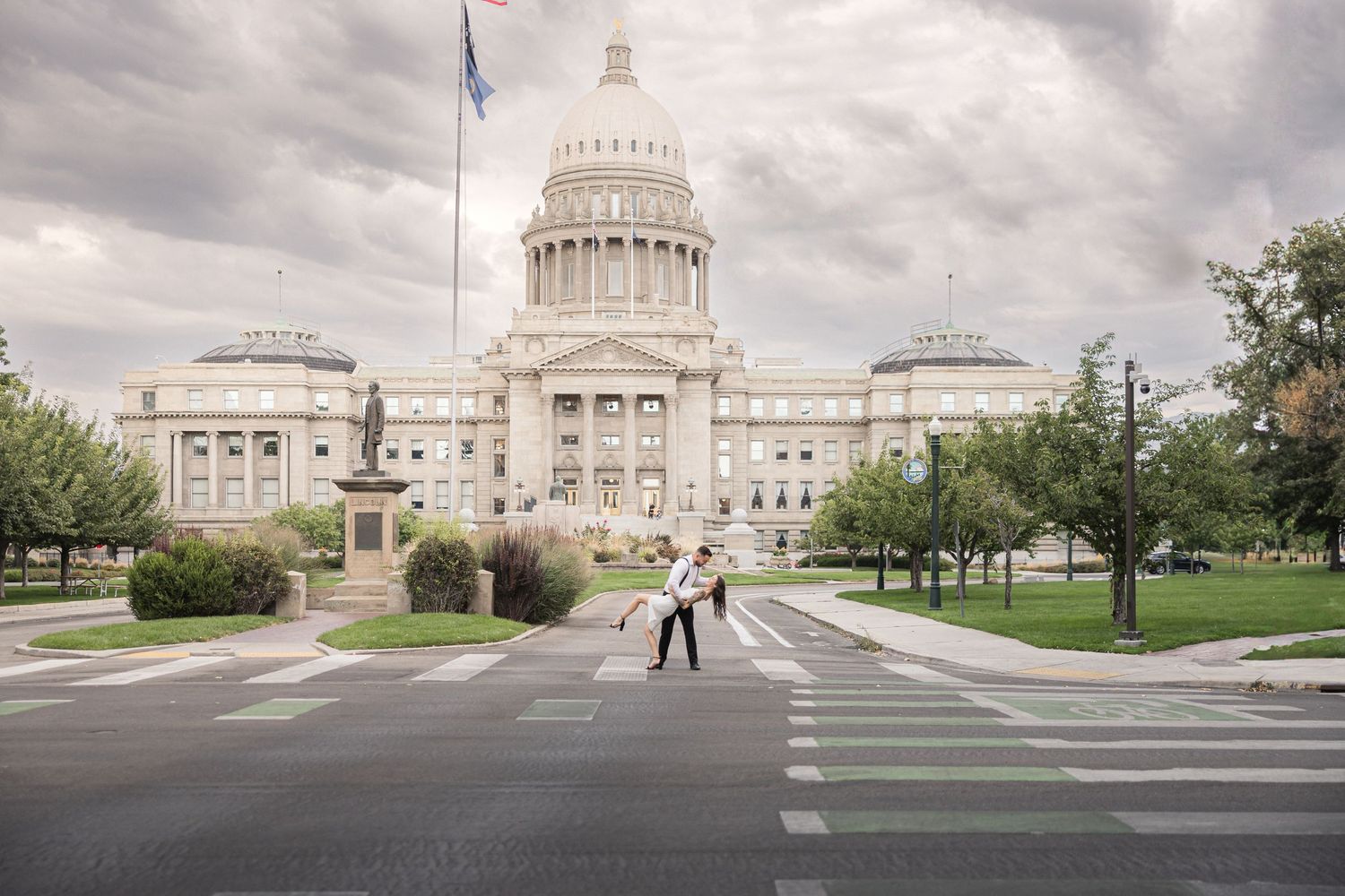A panoramic view of the Texas State Capitol building and grounds in Austin with cloudy skies overhead.