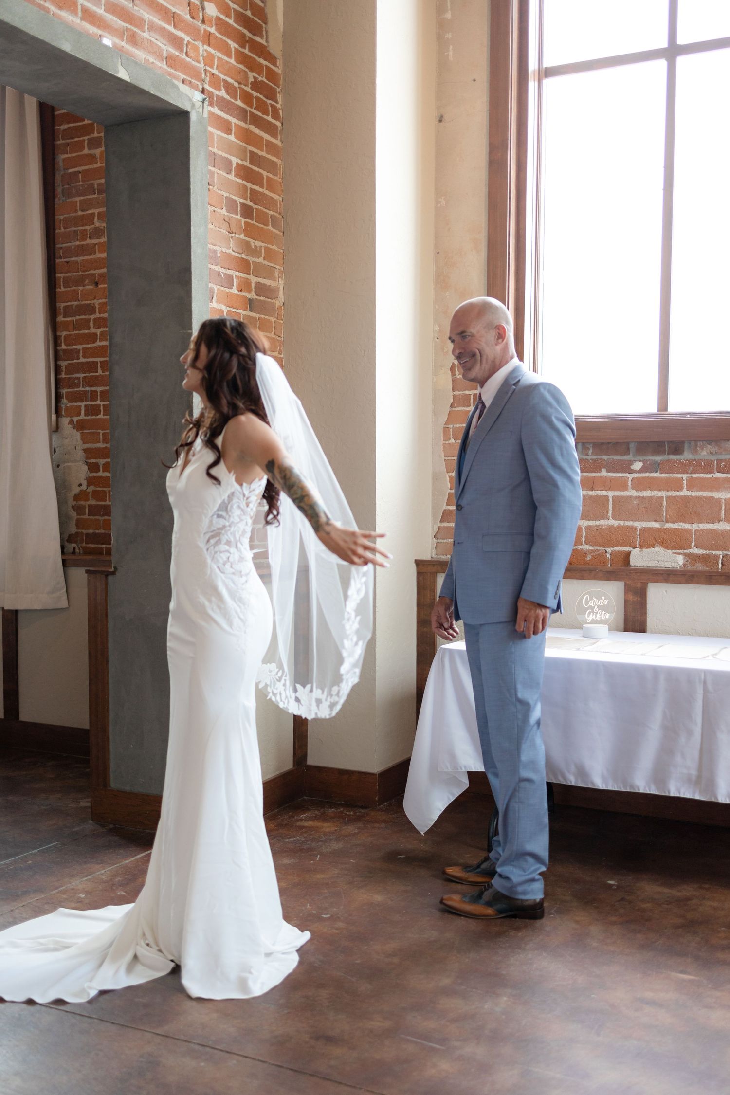 Dramatic first look reveal between couple in wedding attire at rustic venue.